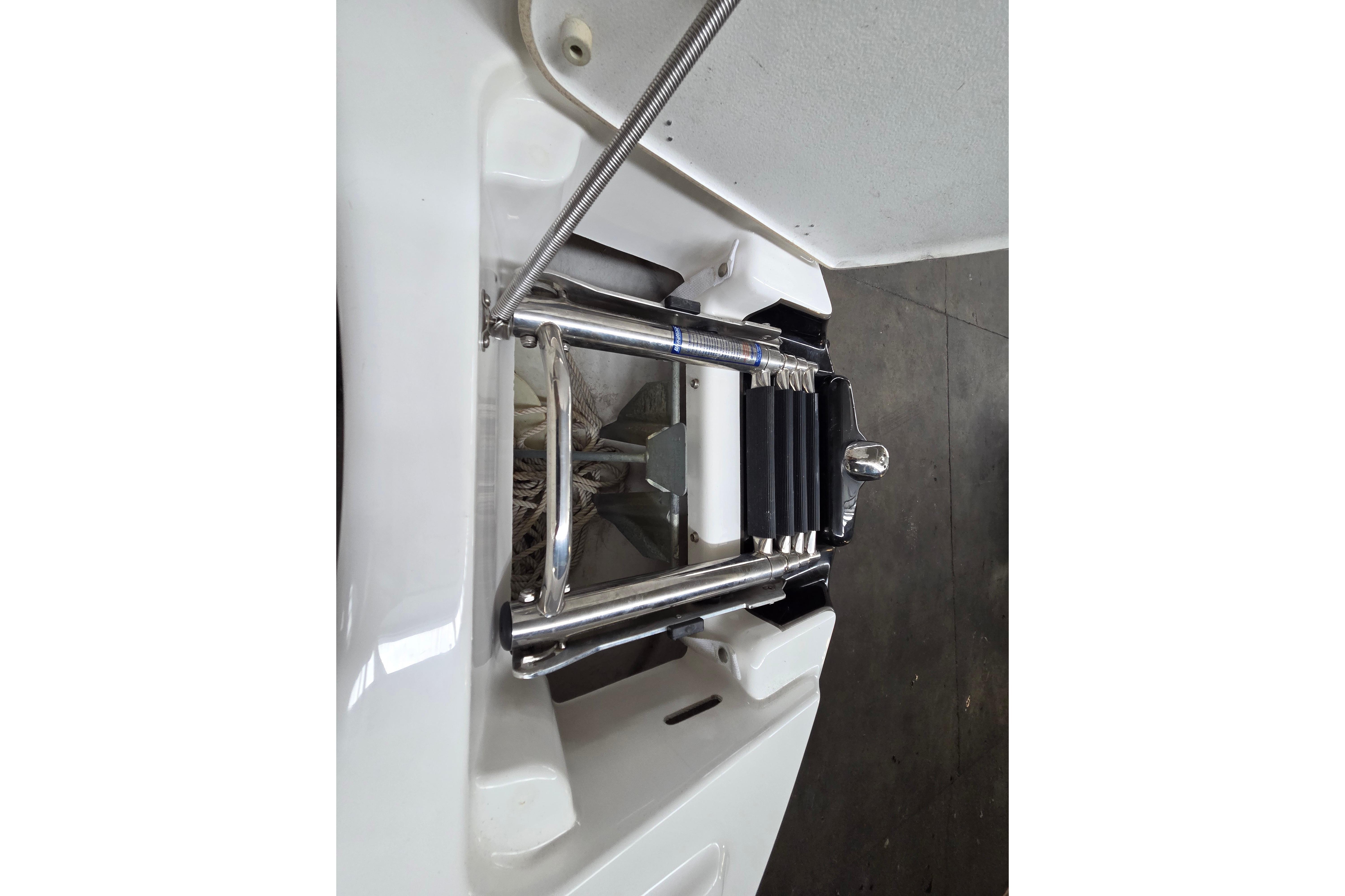 2013 Yamaha 242 Limited S boat ladder, stainless steel, folded on white deck.