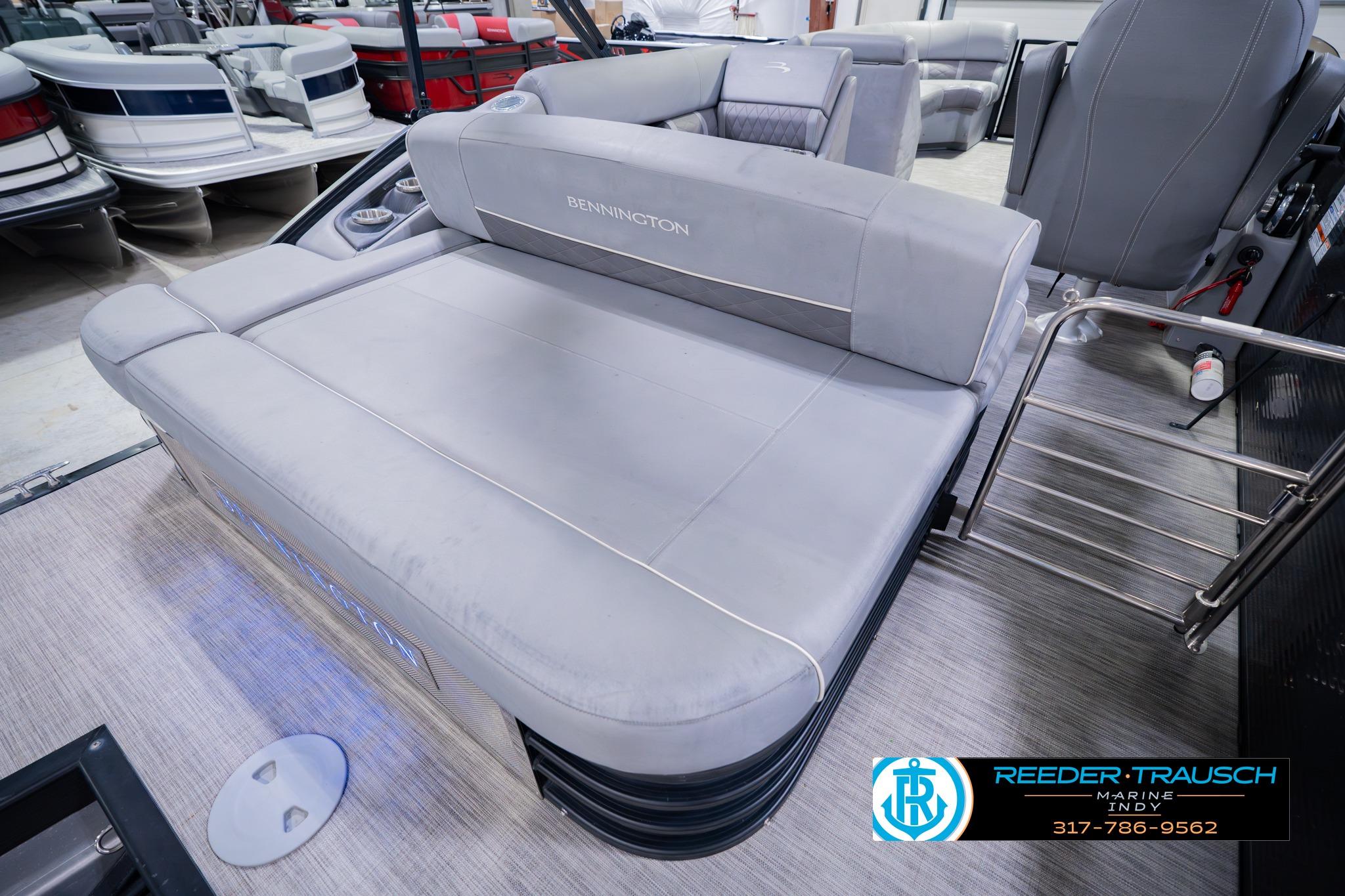 2020 Bennington 22 SSBXP pontoon boat with plush seating in showroom.