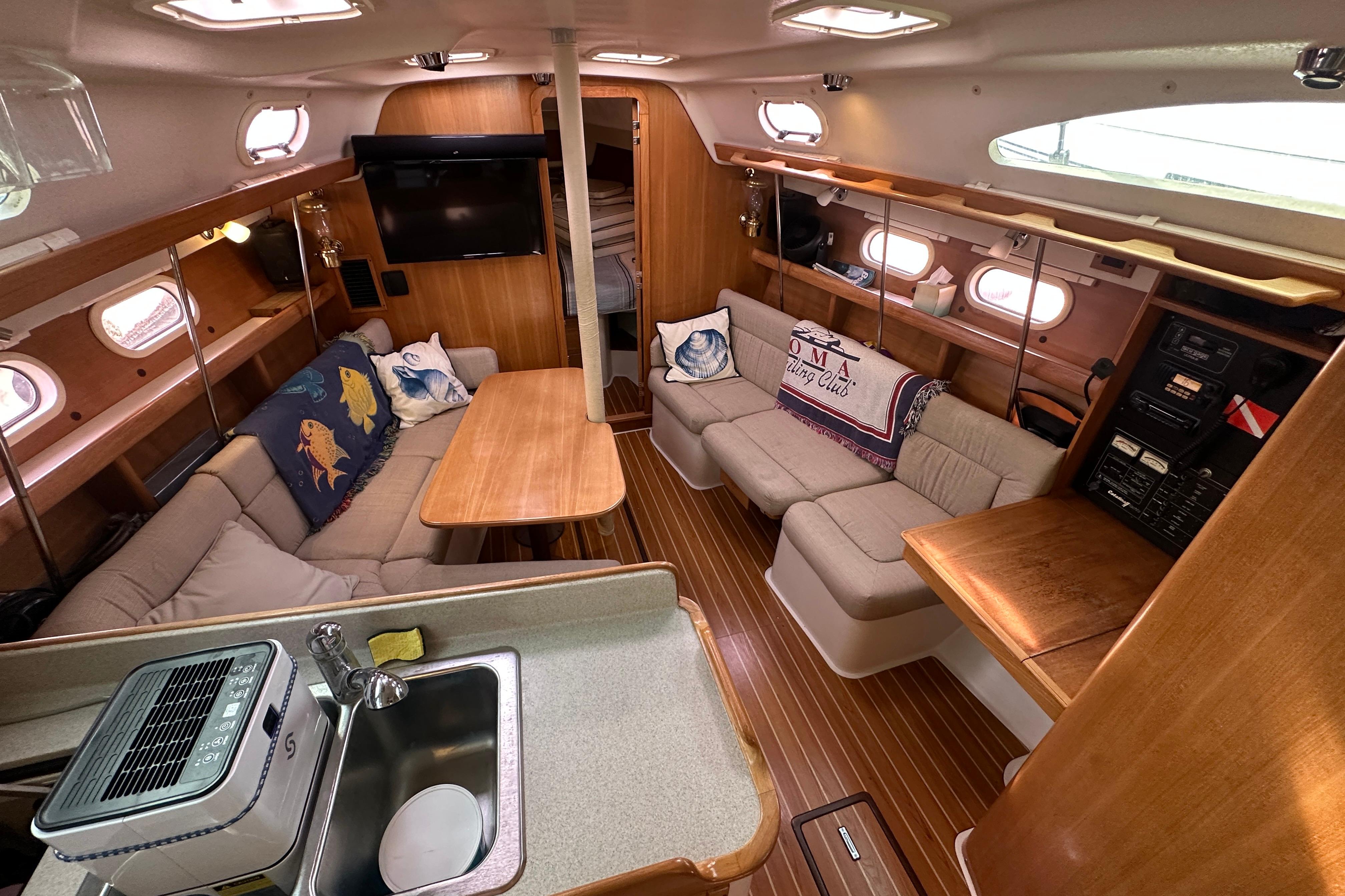 Interior of a 2006 Catalina 387 sailboat with cozy seating and wooden finishes.