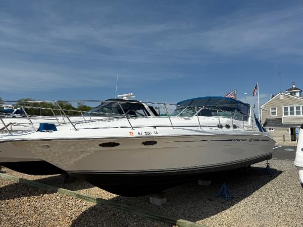 1995 Sea Ray 400 Express Cruiser docked on land under clear blue sky.
