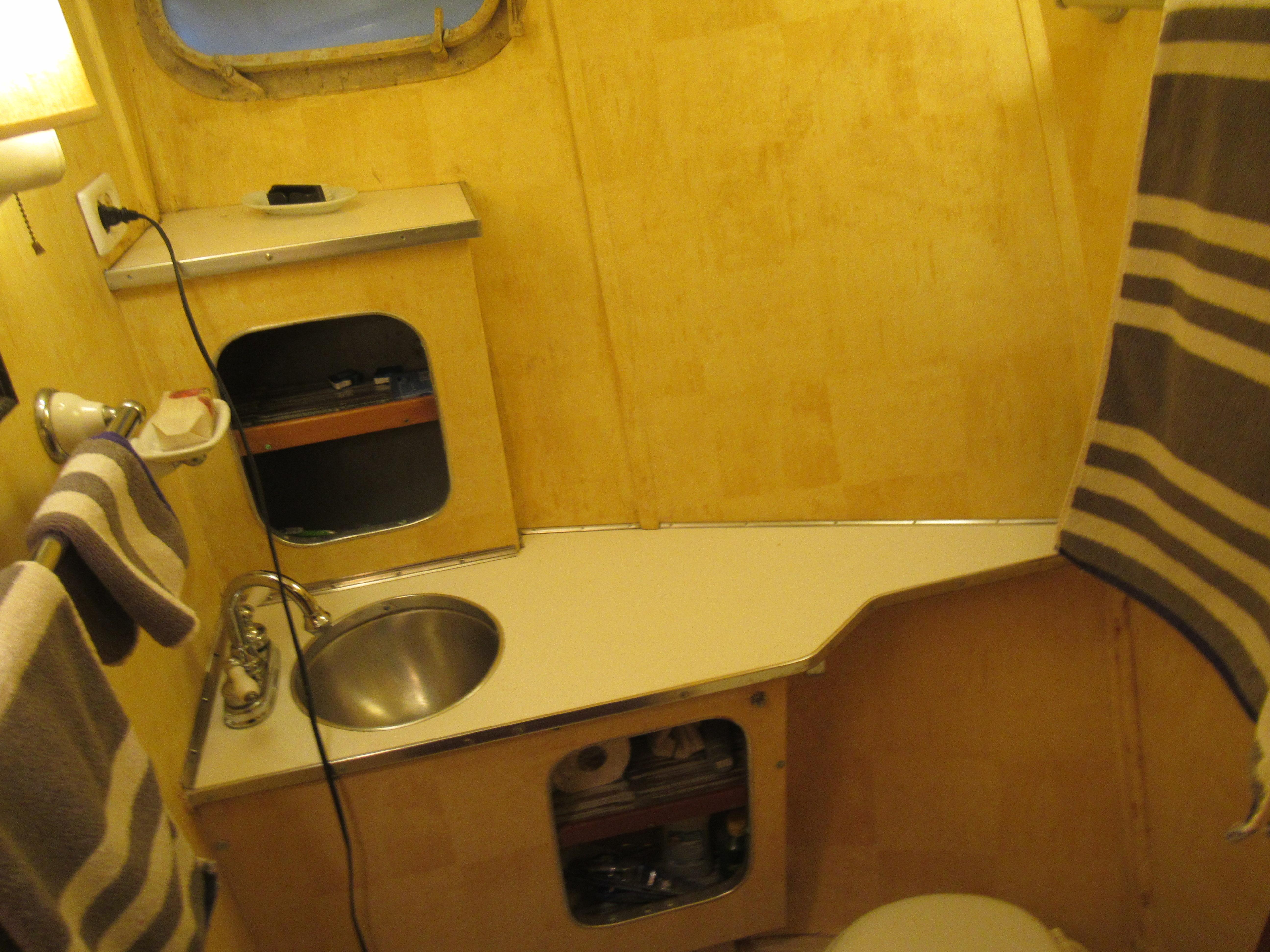 1963 Chris-Craft Constellation bathroom with wooden interior and compact sink.
