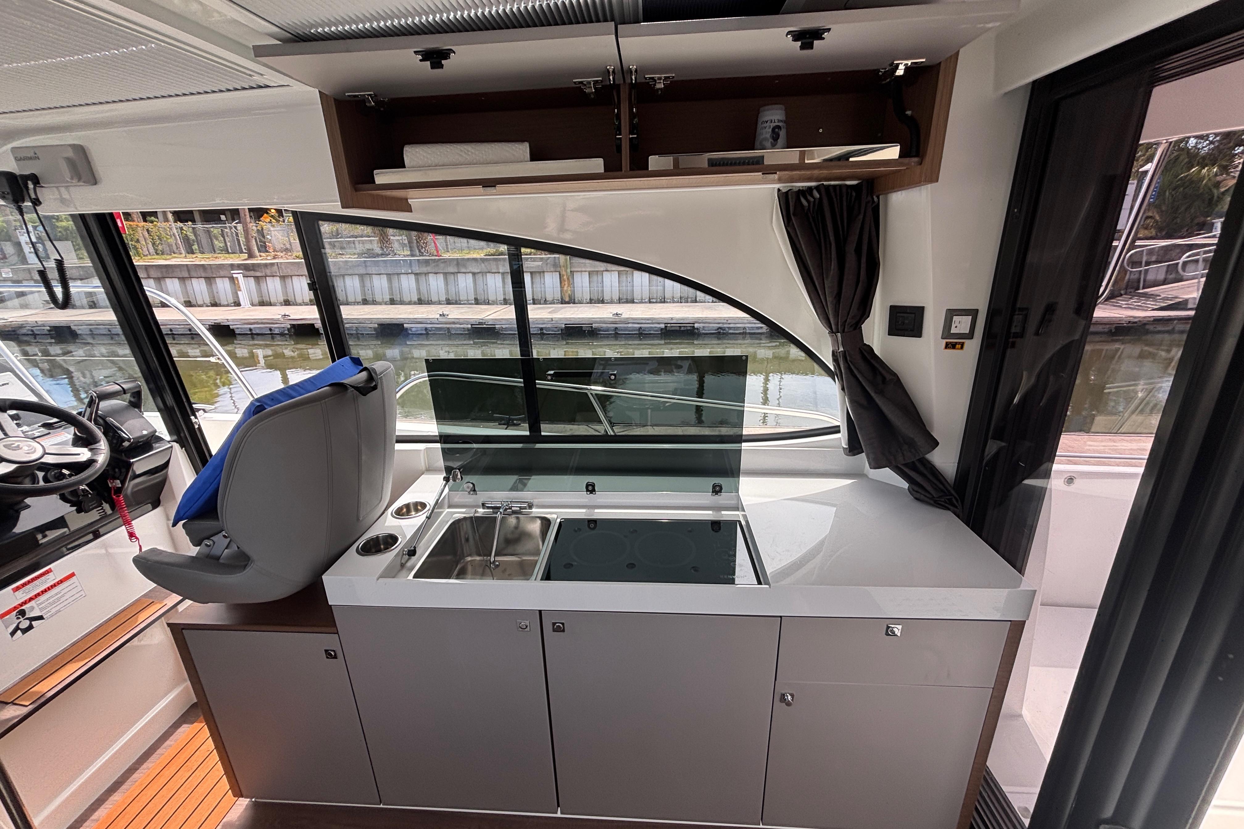 Interior of 2024 Beneteau Antares 11, featuring modern kitchen and helm station.