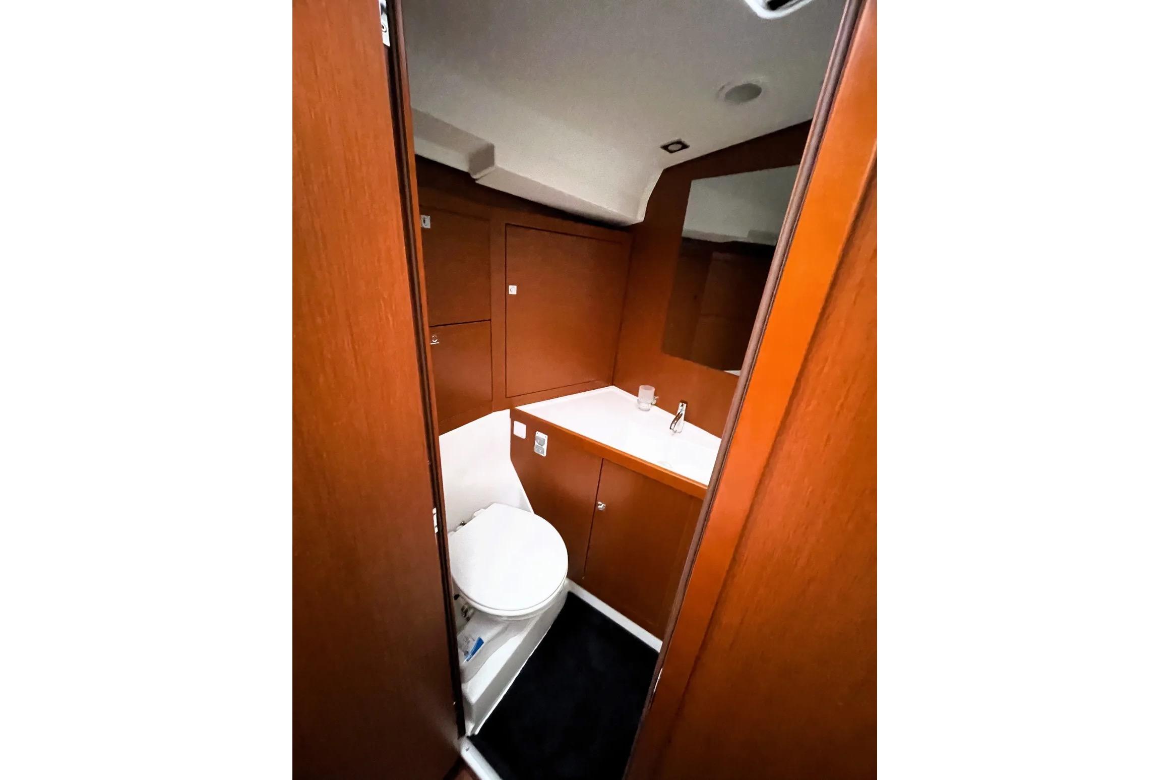Interior of 2018 Beneteau Oceanis 45 yacht bathroom with wooden cabinetry and modern fixtures.