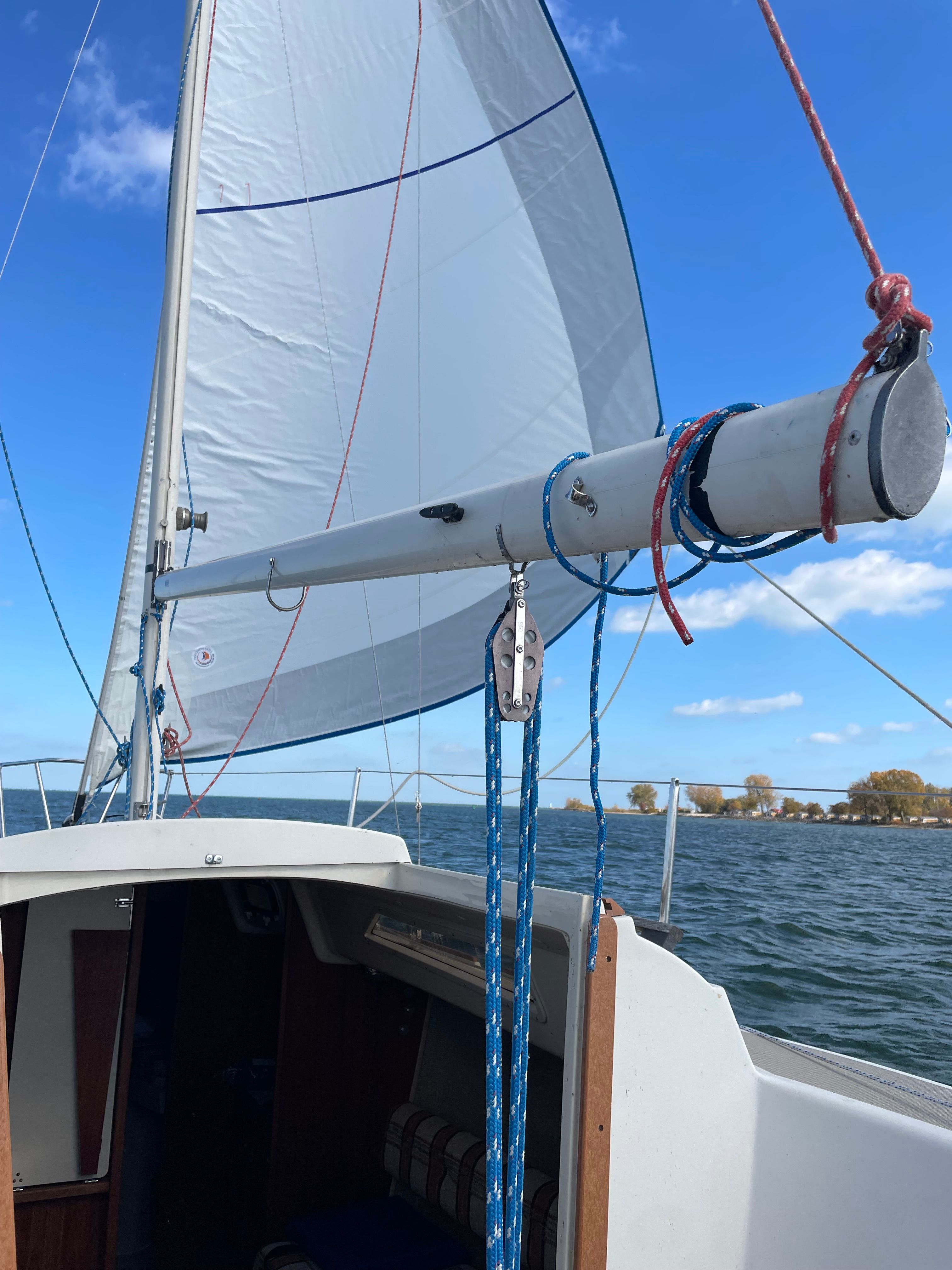 1984 O'Day 25 sailboat on open water under clear sky.