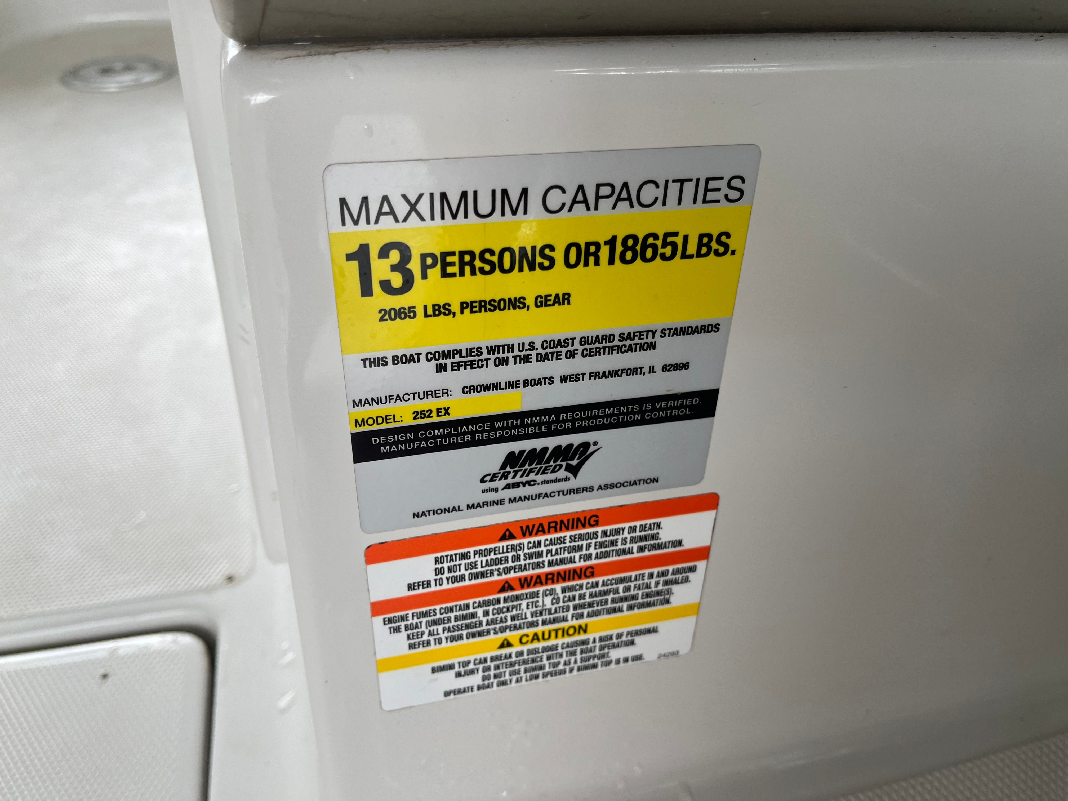 Sign on a boat displaying capacity and safety information.