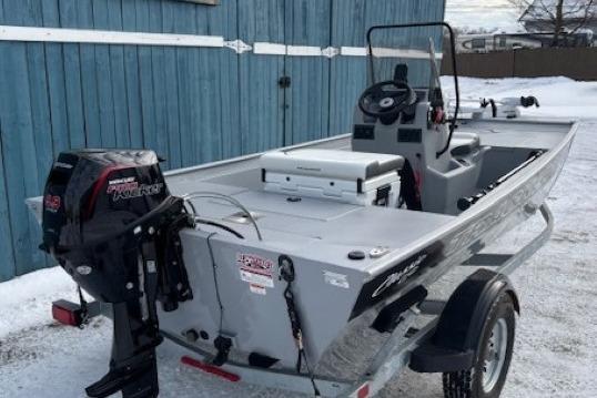 2026 Tracker Bass Tracker Classic CC boat on trailer, parked near blue building.