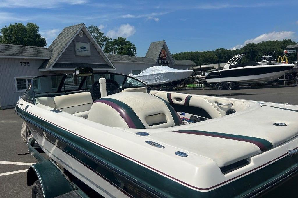 1999 Malibu Response boat parked at a dealership with other boats in the background.