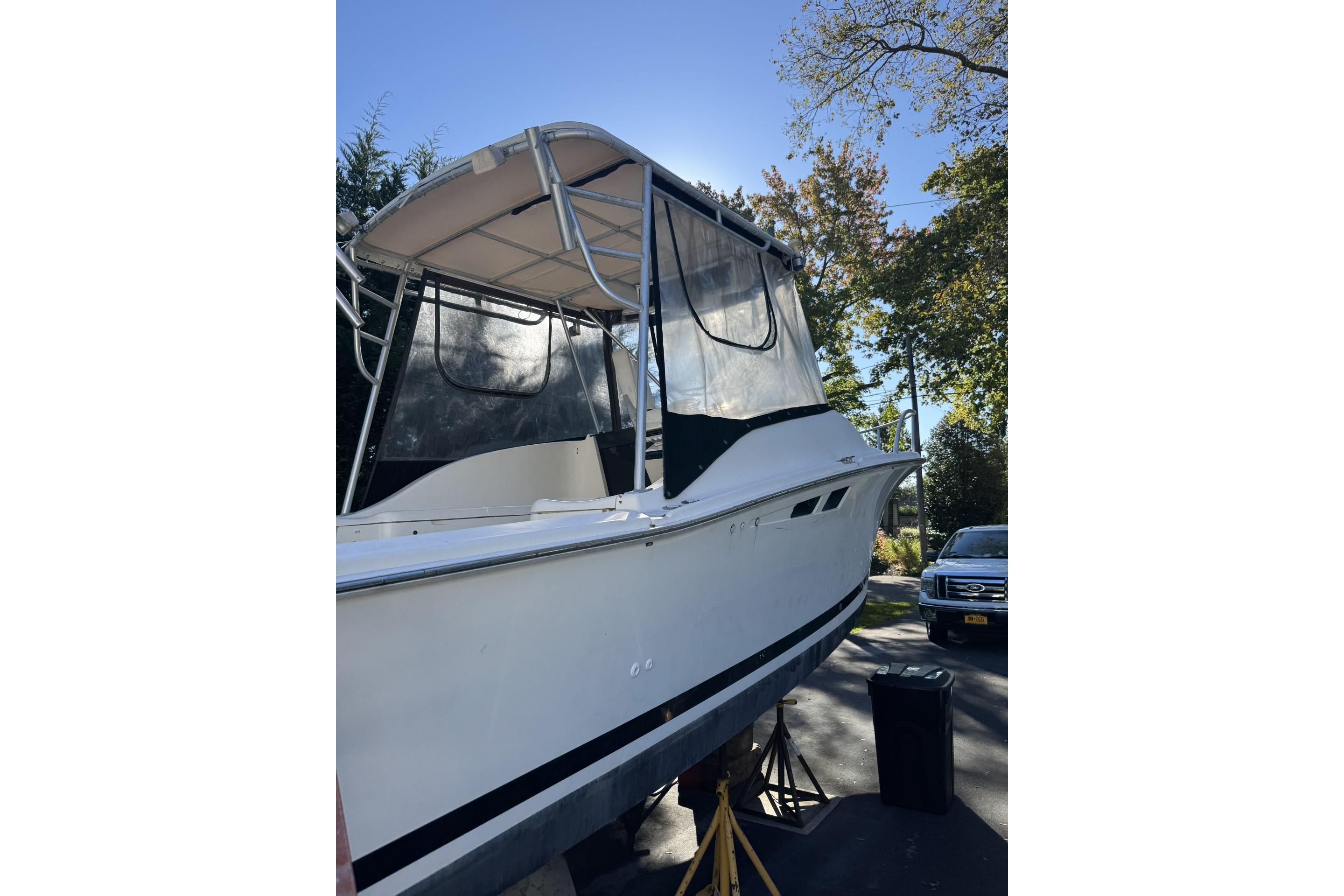 1993 Luhr's Tournament boat with canopy, parked outdoors on a sunny day.