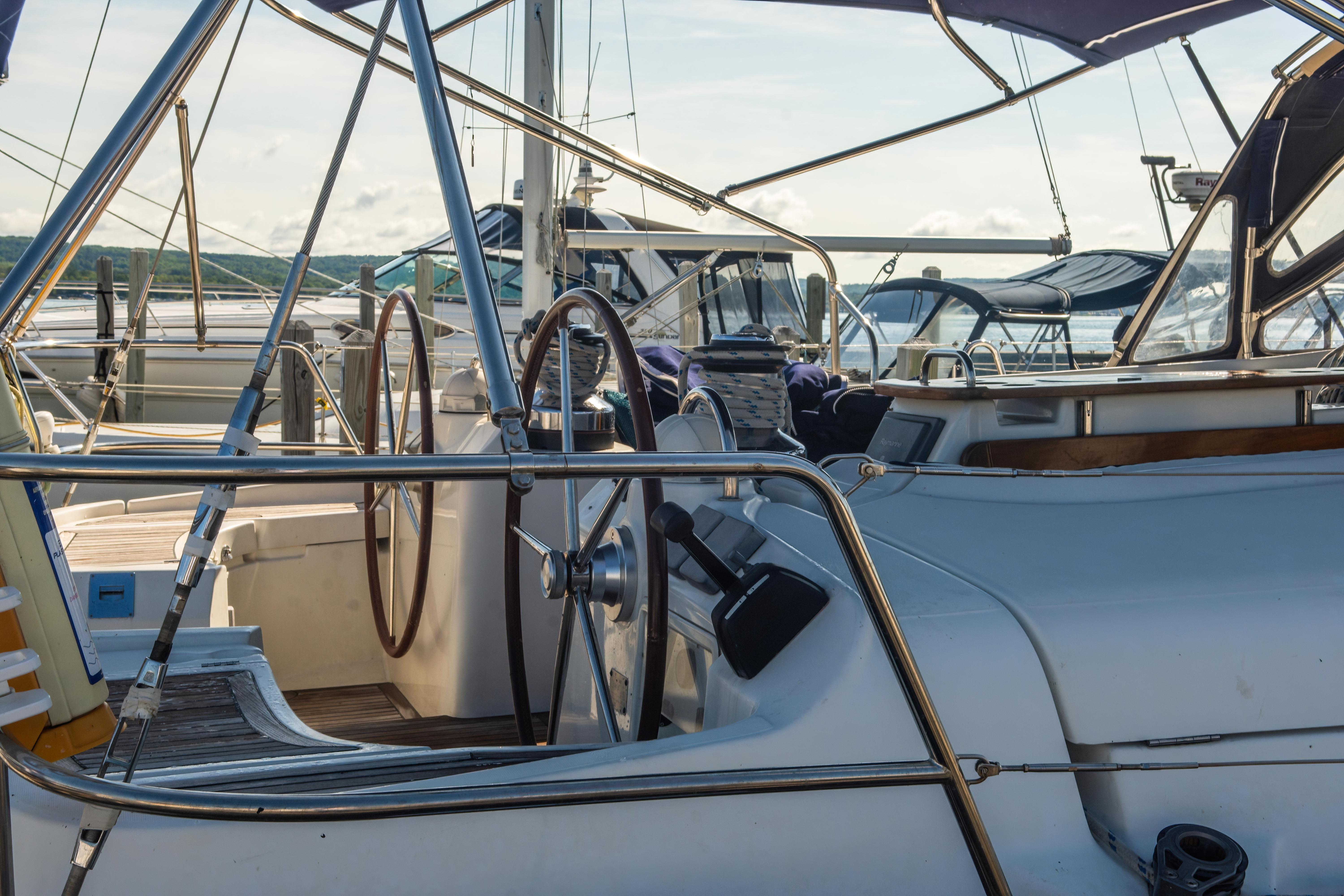 2007 Beneteau Oceanis 523 yacht cockpit with dual steering wheels, docked at marina.