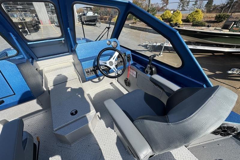 Interior of 2026 SeaArk Dynasty 2.0 boat with steering wheel and seating.