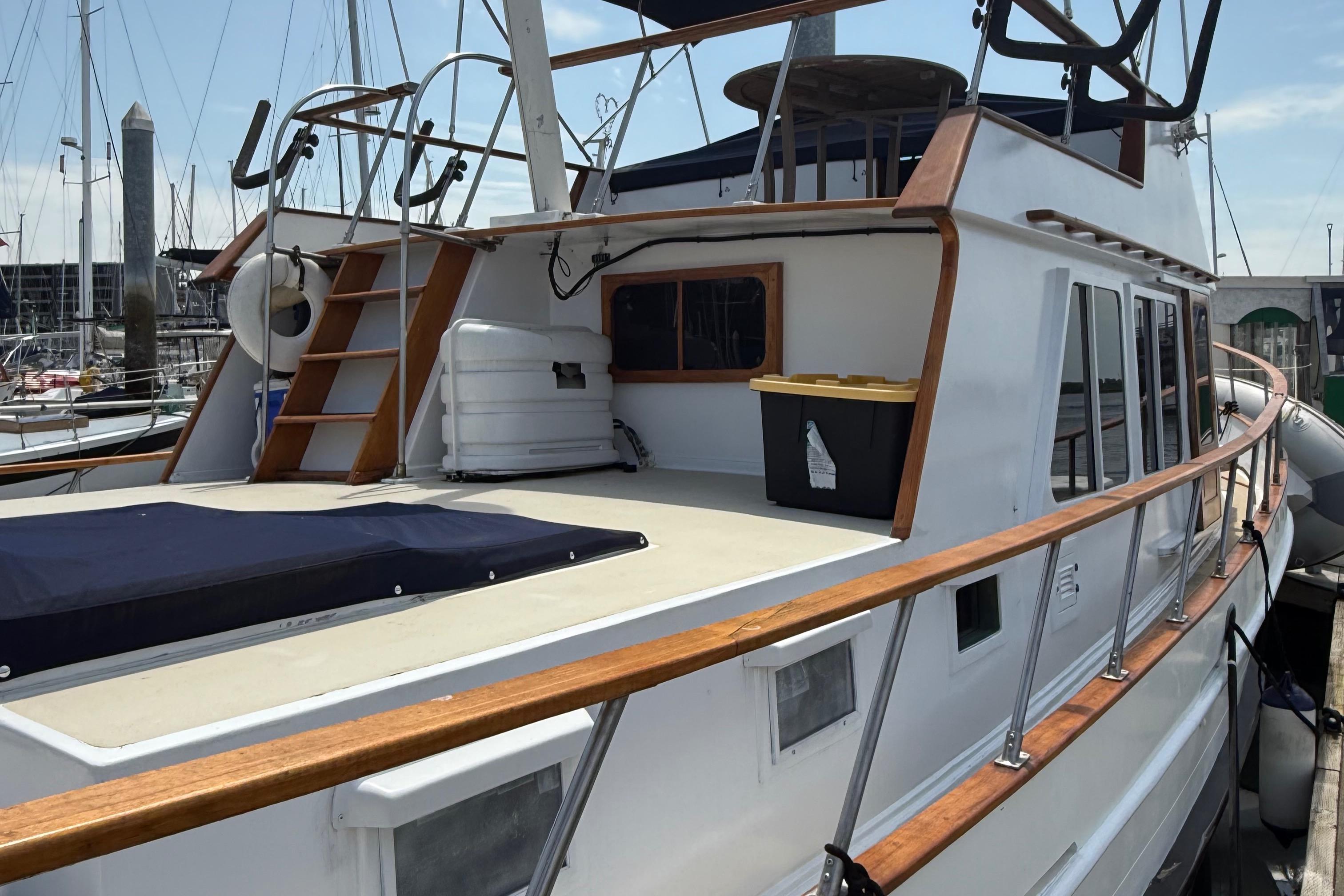 1978 DeFever 39 yacht with wooden railings docked at a marina.