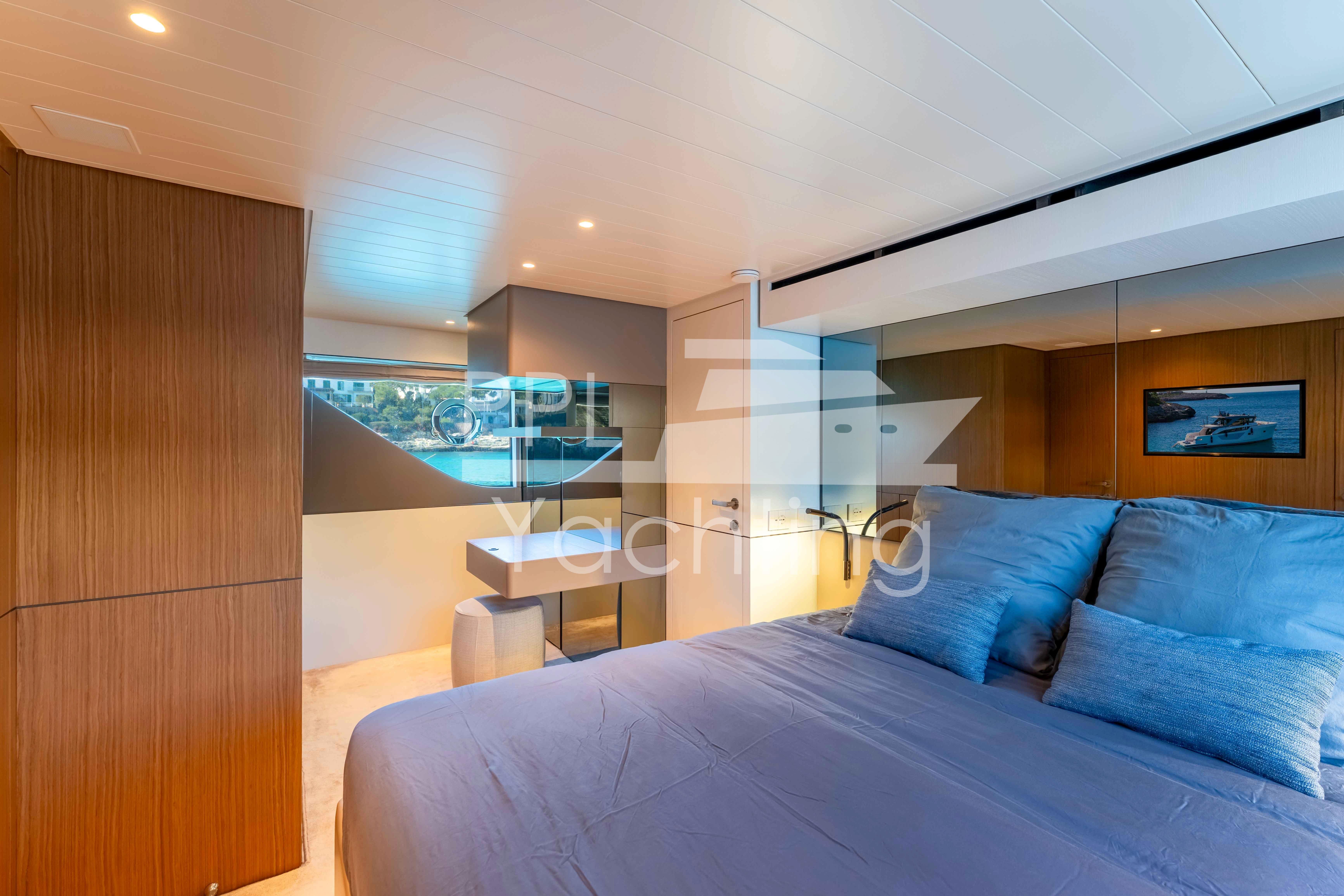 Luxurious bedroom interior of 2024 Bluegame BGX63 yacht with modern design and scenic window view.