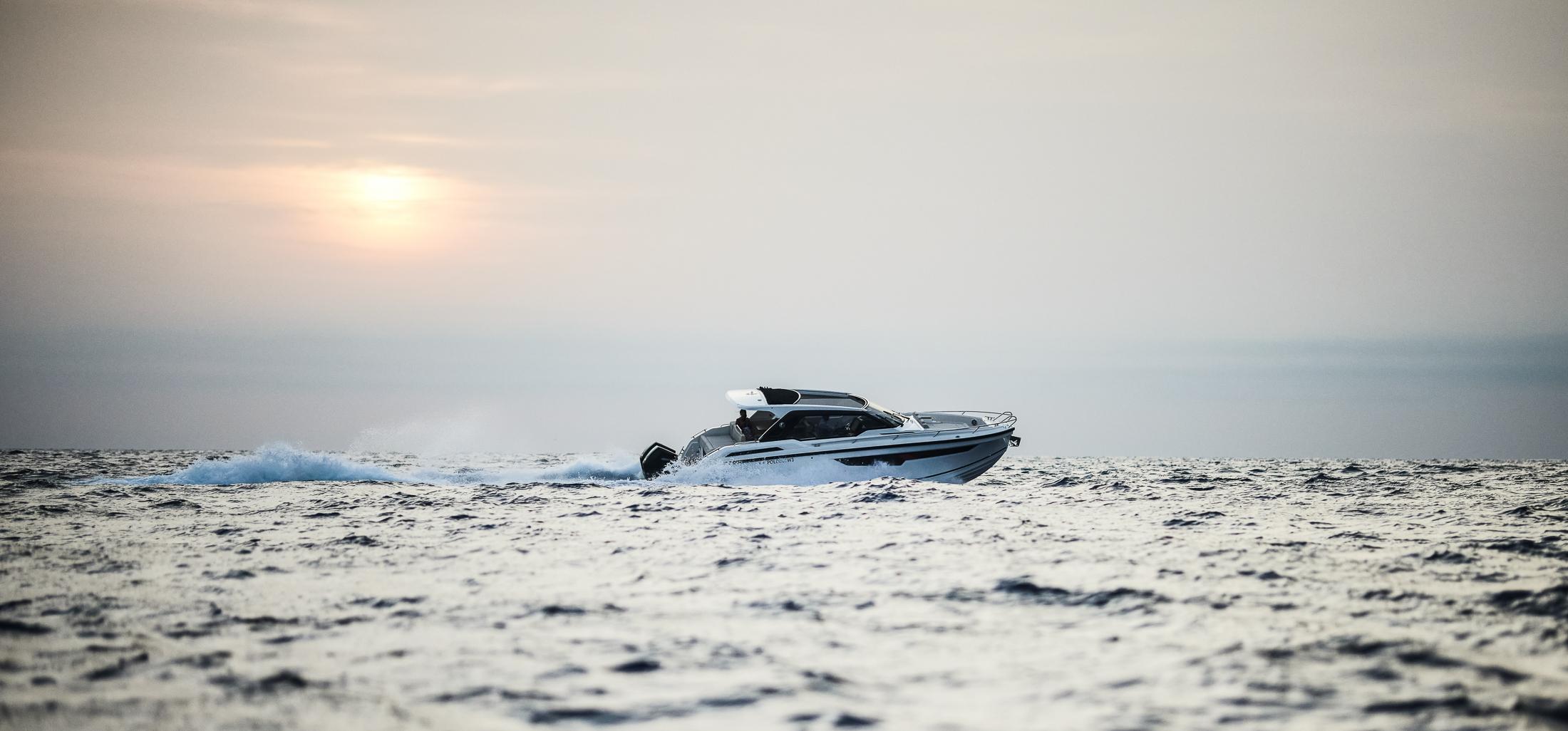 2024 Skamander Sorrento boat cruising on open water at sunset.