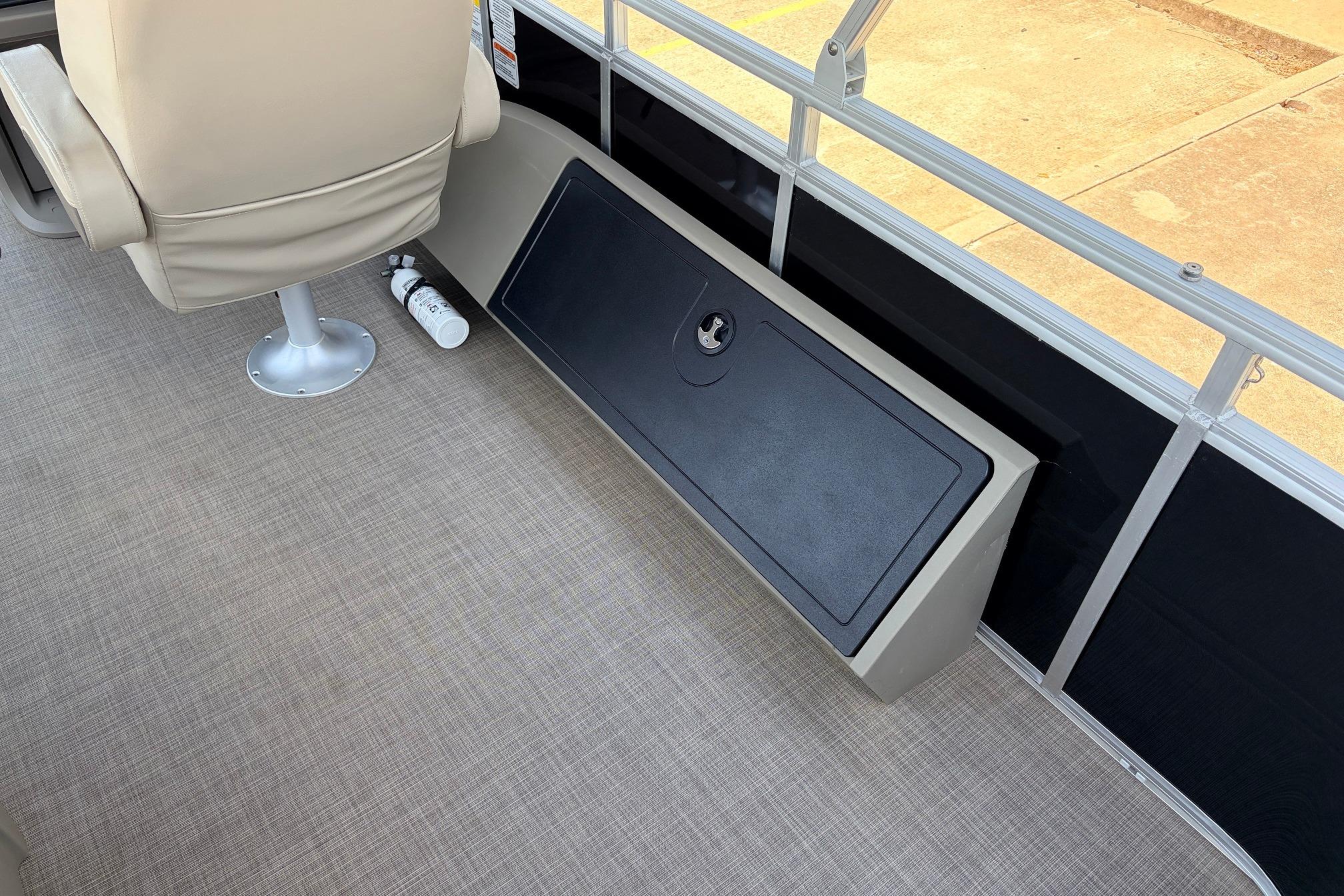 2024 Sun Tracker SportFish 22 XP3 interior with beige seating and storage compartment.