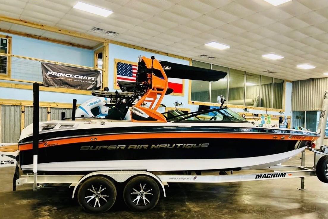 2013 Nautique Super Air Nautique 230 boat on trailer in showroom.