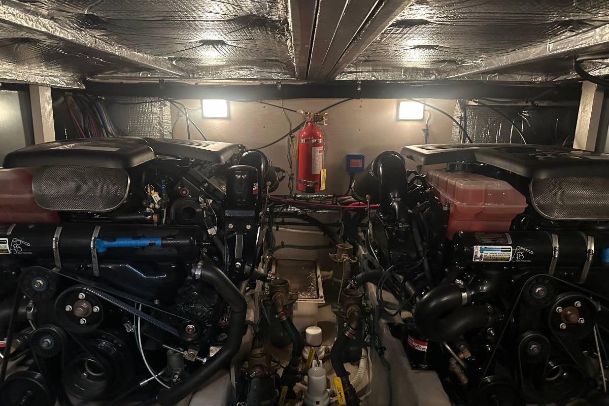 Engine room of a 2004 Sea Ray 390 Motor Yacht with dual engines and fire extinguisher.