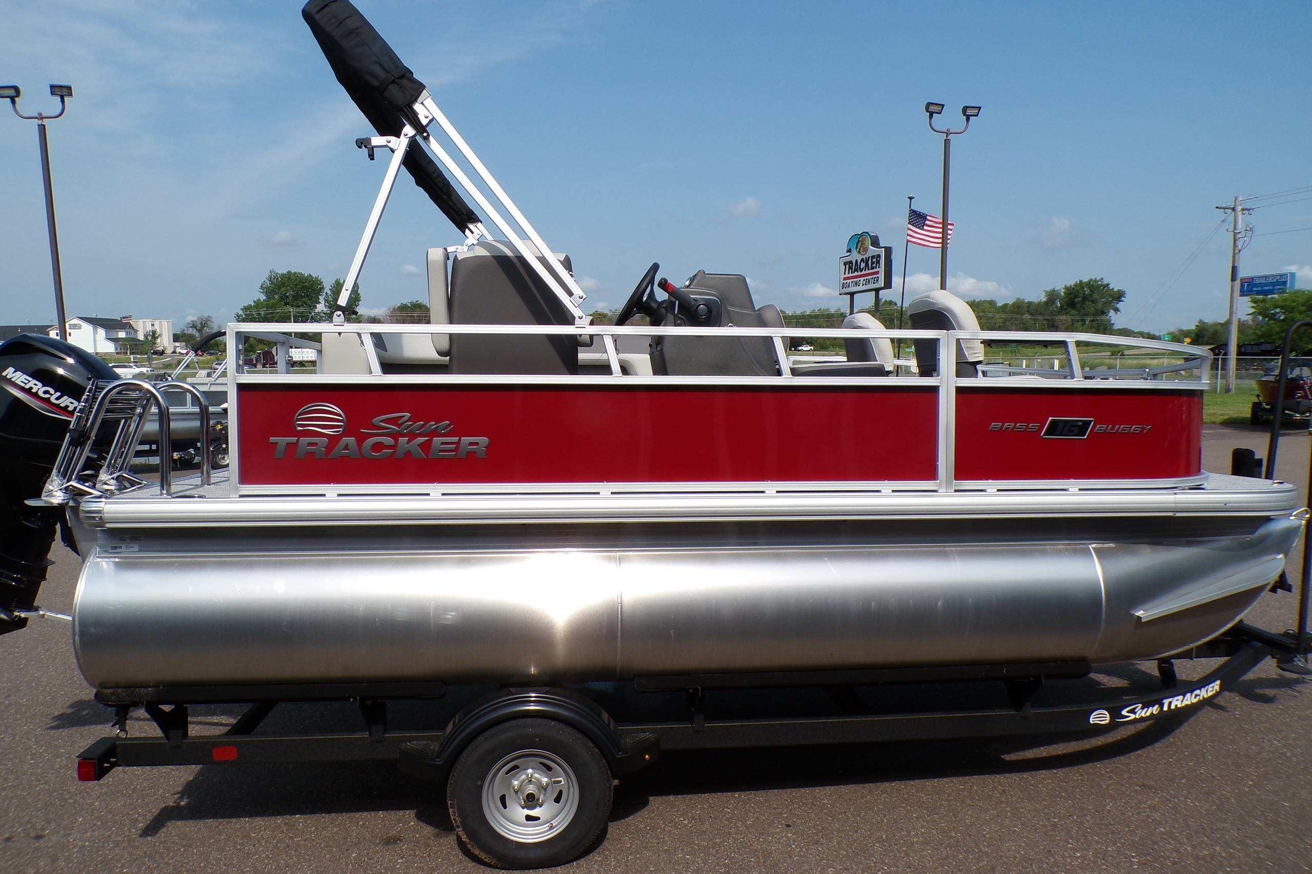 2026 Sun Tracker Bass Buggy 16 XL Select pontoon boat on trailer, red and silver design.