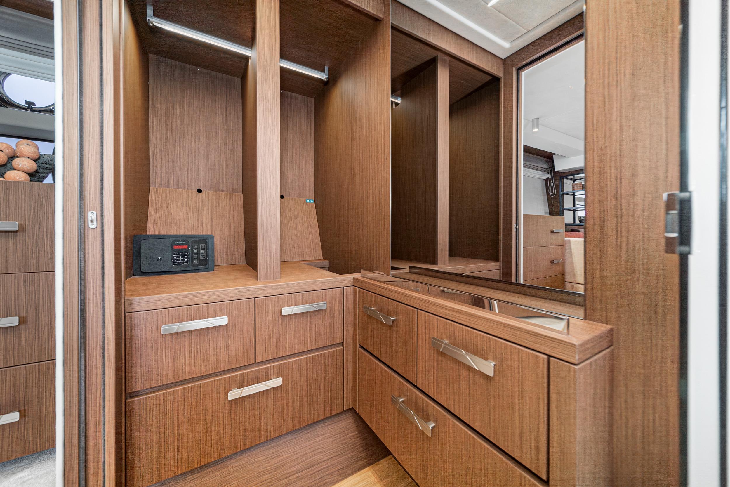 Luxurious wooden cabinetry in 2024 Prestige X60 yacht interior, featuring sleek drawers and a safe.