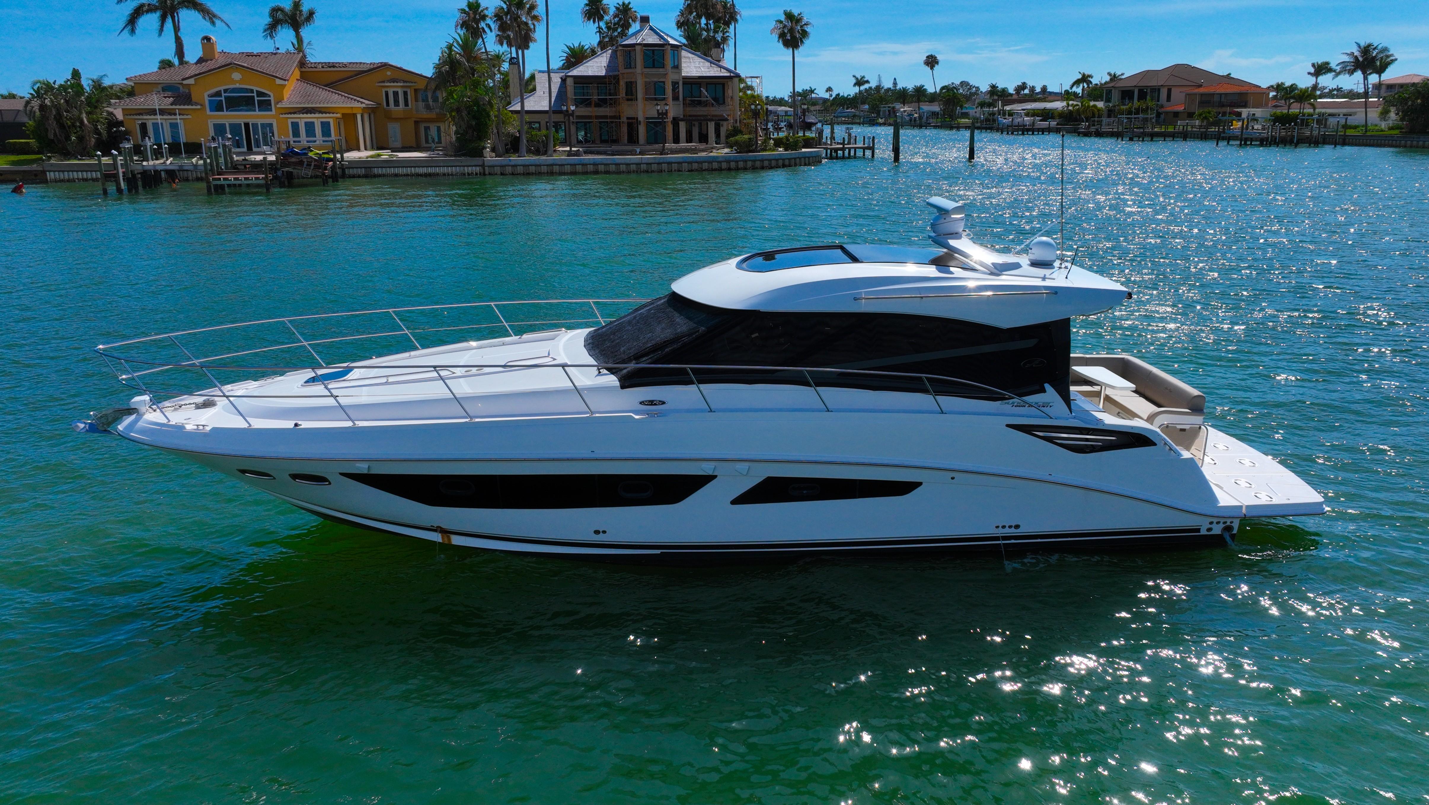 2016 Sea Ray 470 Sundancer yacht cruising on a sunny day near waterfront homes.