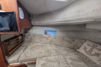 Port side view of V-berthinterior with cushioned seating and nautical decor.