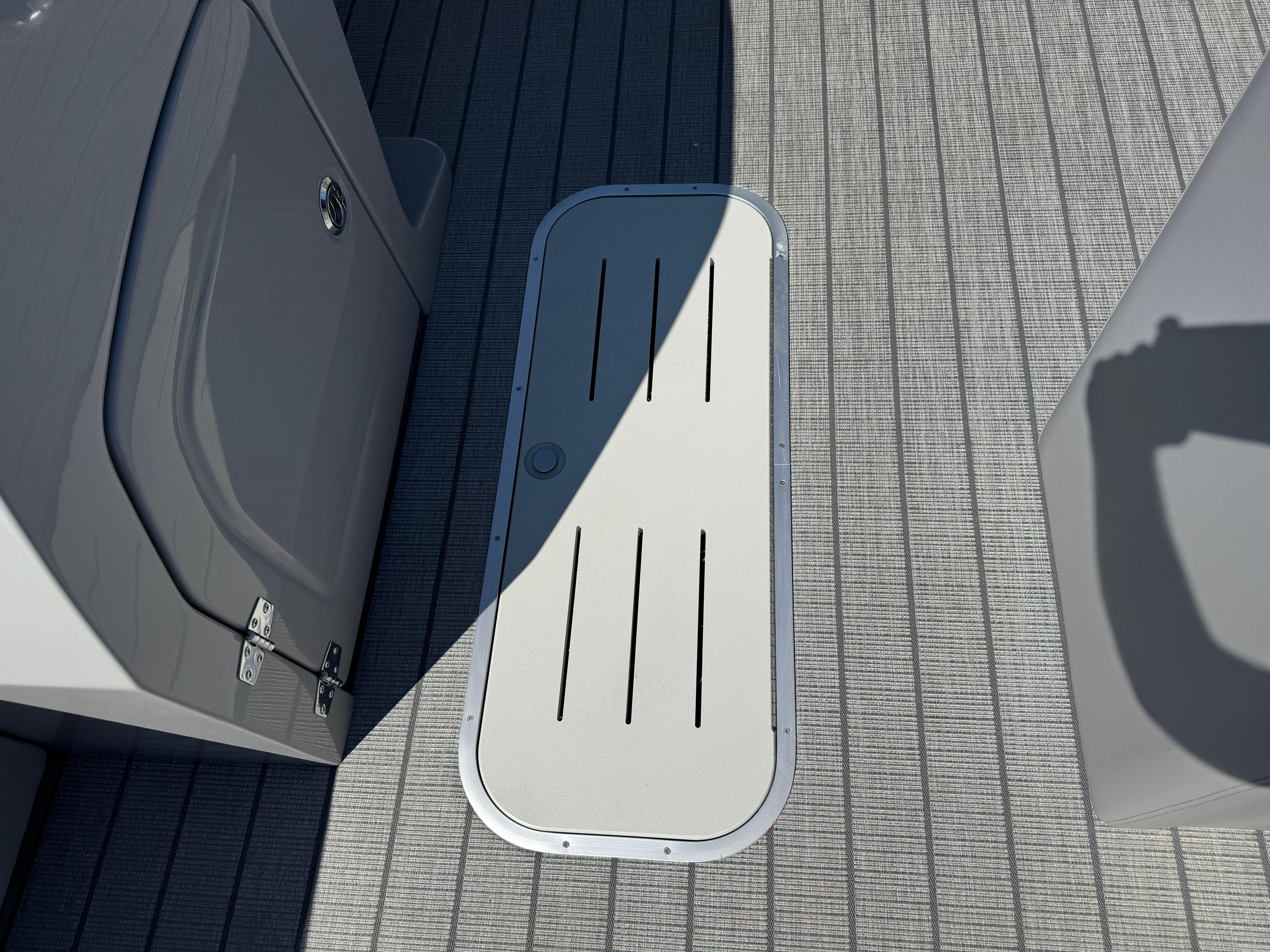 Deck of 2026 Bentley Pontoons Legacy 223 Navigator with storage hatch.