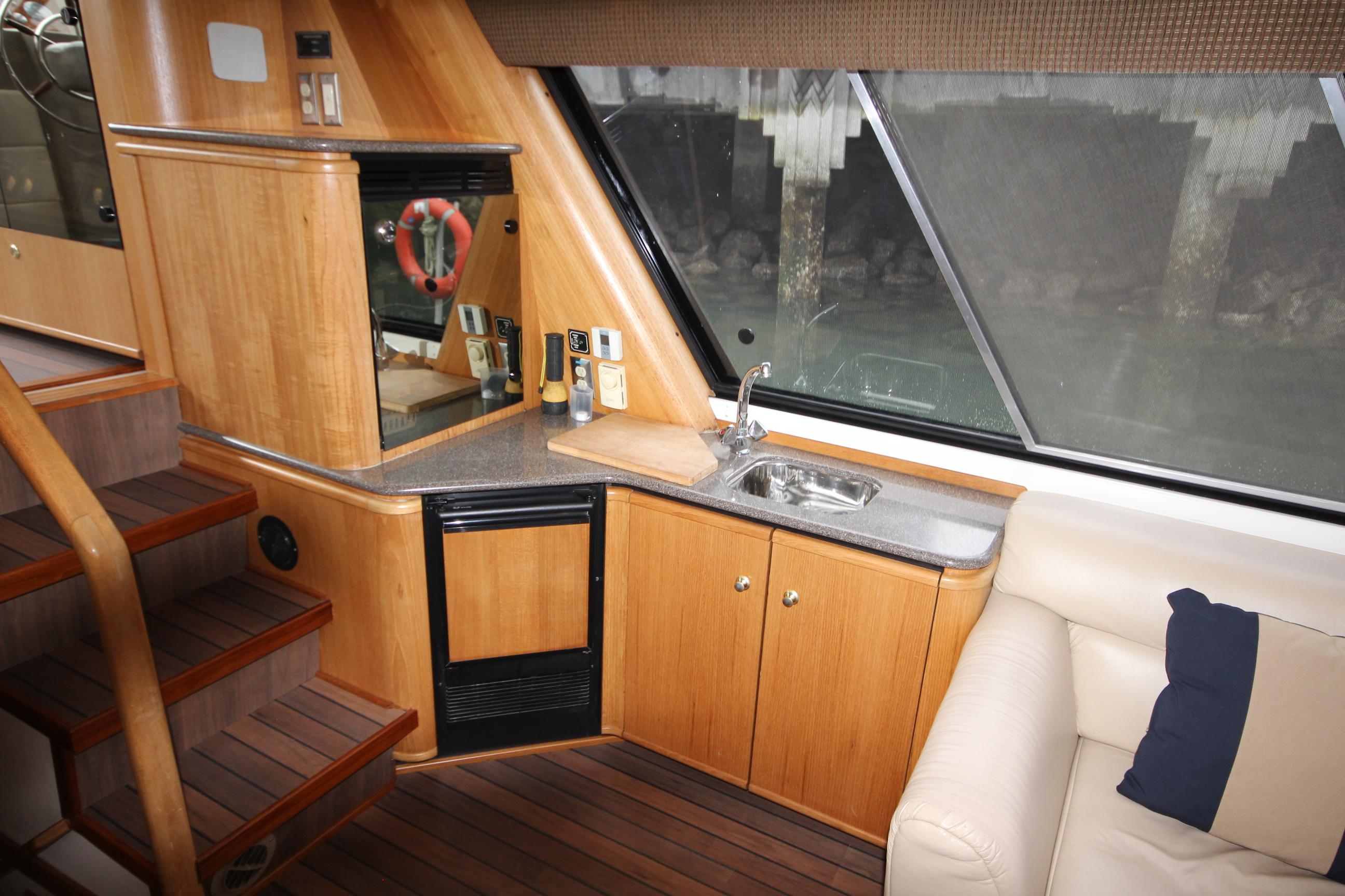 Interior of 1999 Bayliner 4788 Motoryacht with wood paneling and kitchenette.