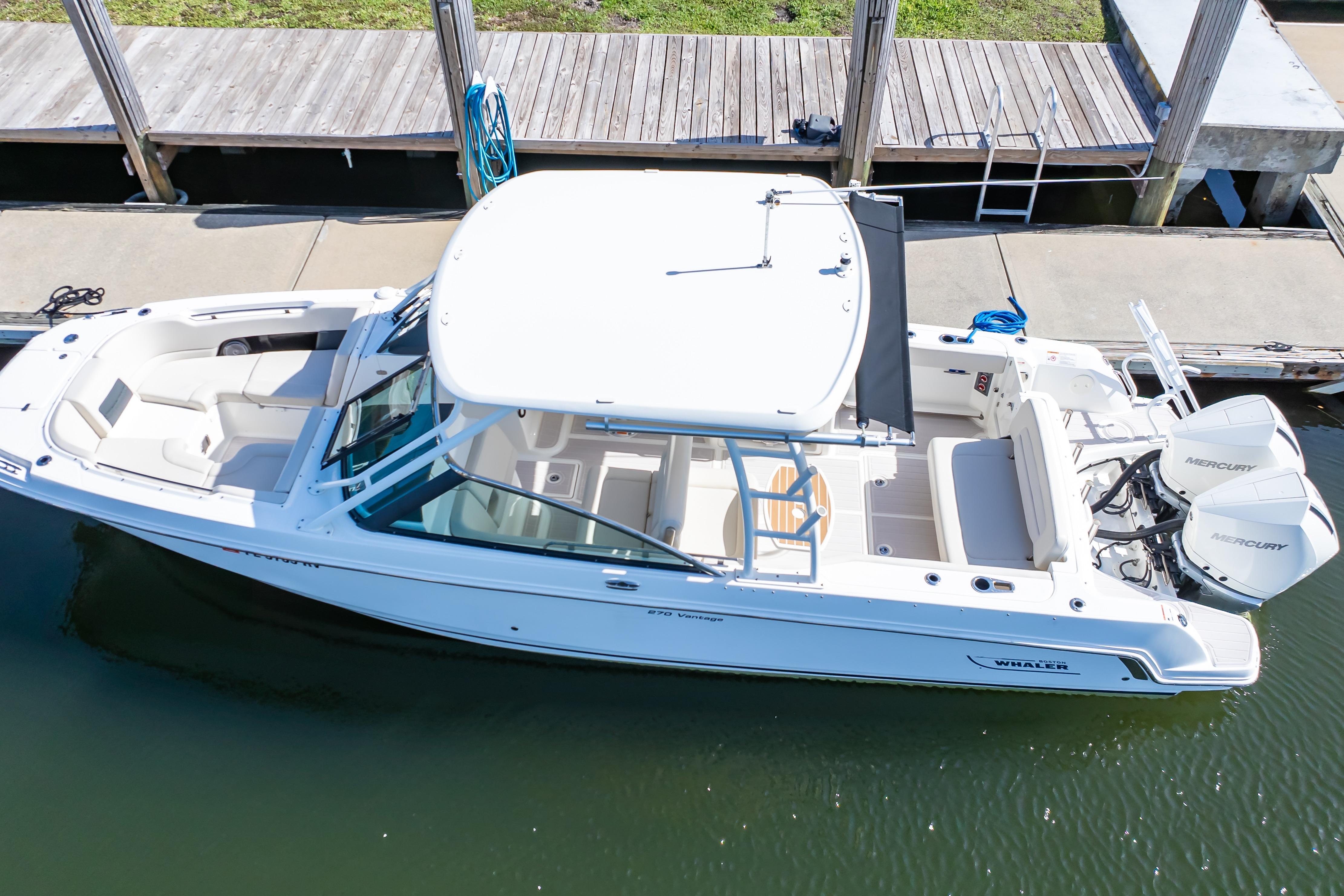 2019 Boston Whaler 270 Vantage boat docked, featuring dual Mercury engines and spacious seating.