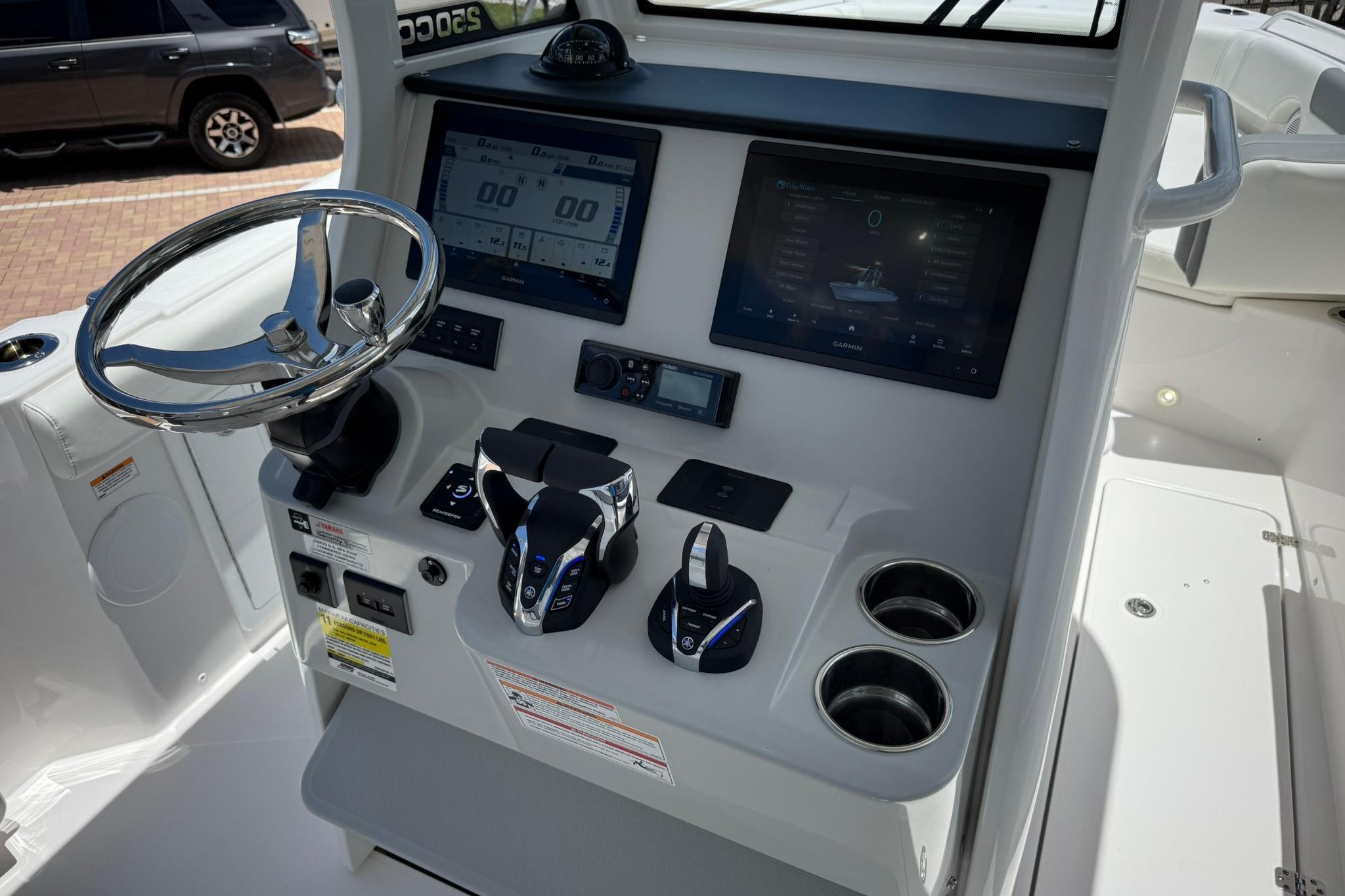 2026 Edgewater 250CC boat dashboard with steering wheel, dual screens, and controls.