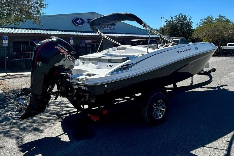 2025 Tahoe T18 boat on trailer, parked outdoors, with Mercury outboard motor.