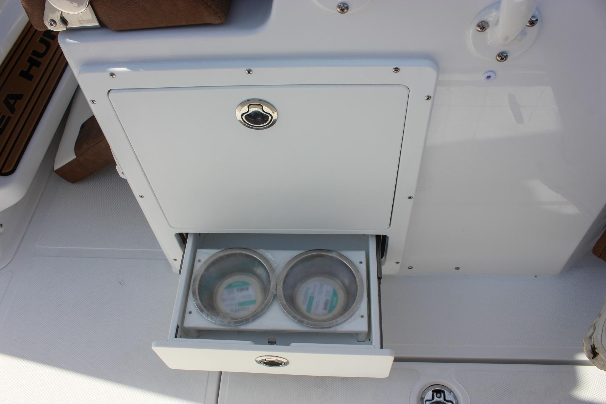 2027 Sea Hunt Ultra 275 SE boat with open storage compartment and cup holders.