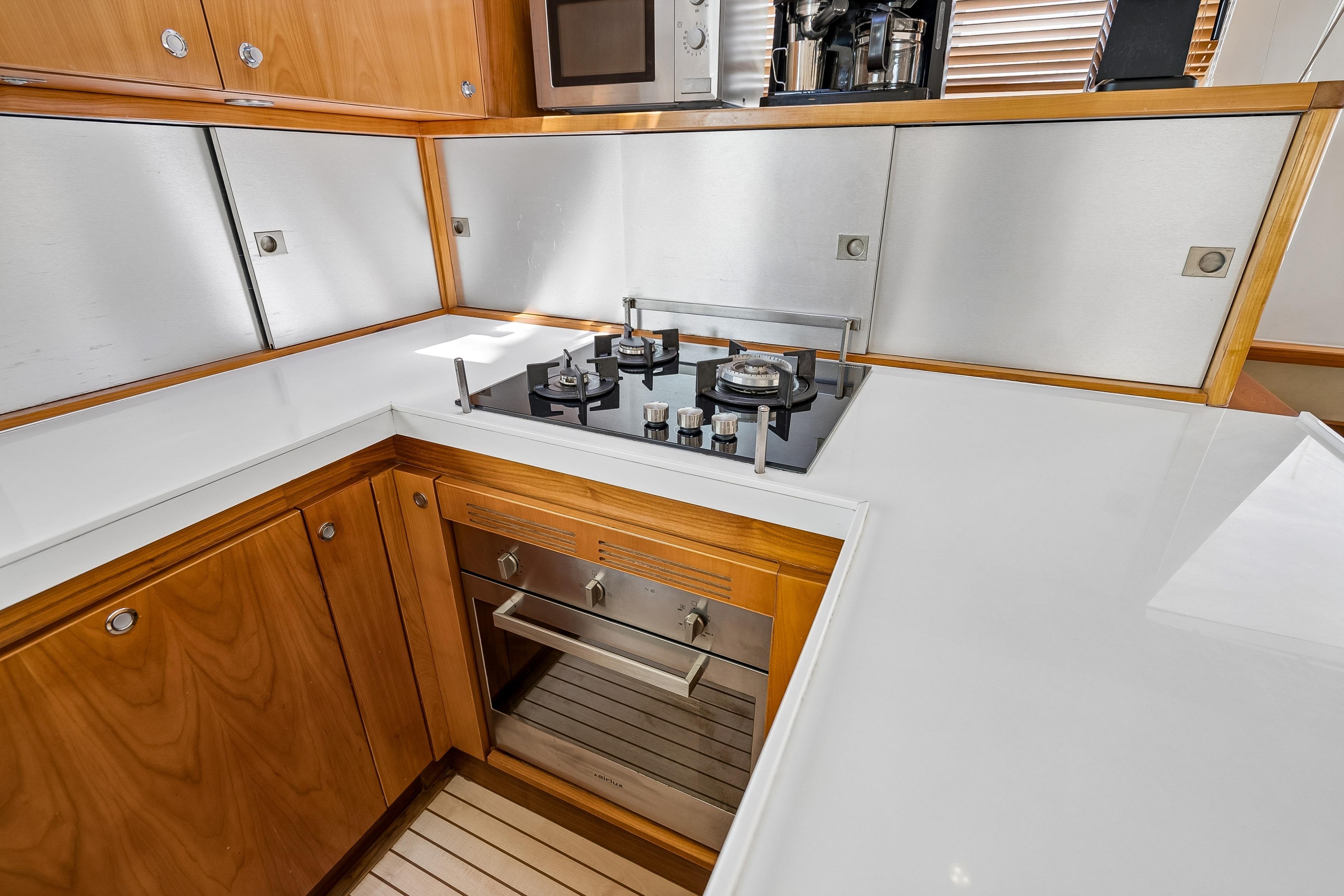 Modern kitchen in a 2009 Catana 65 yacht with sleek appliances and wooden cabinetry.