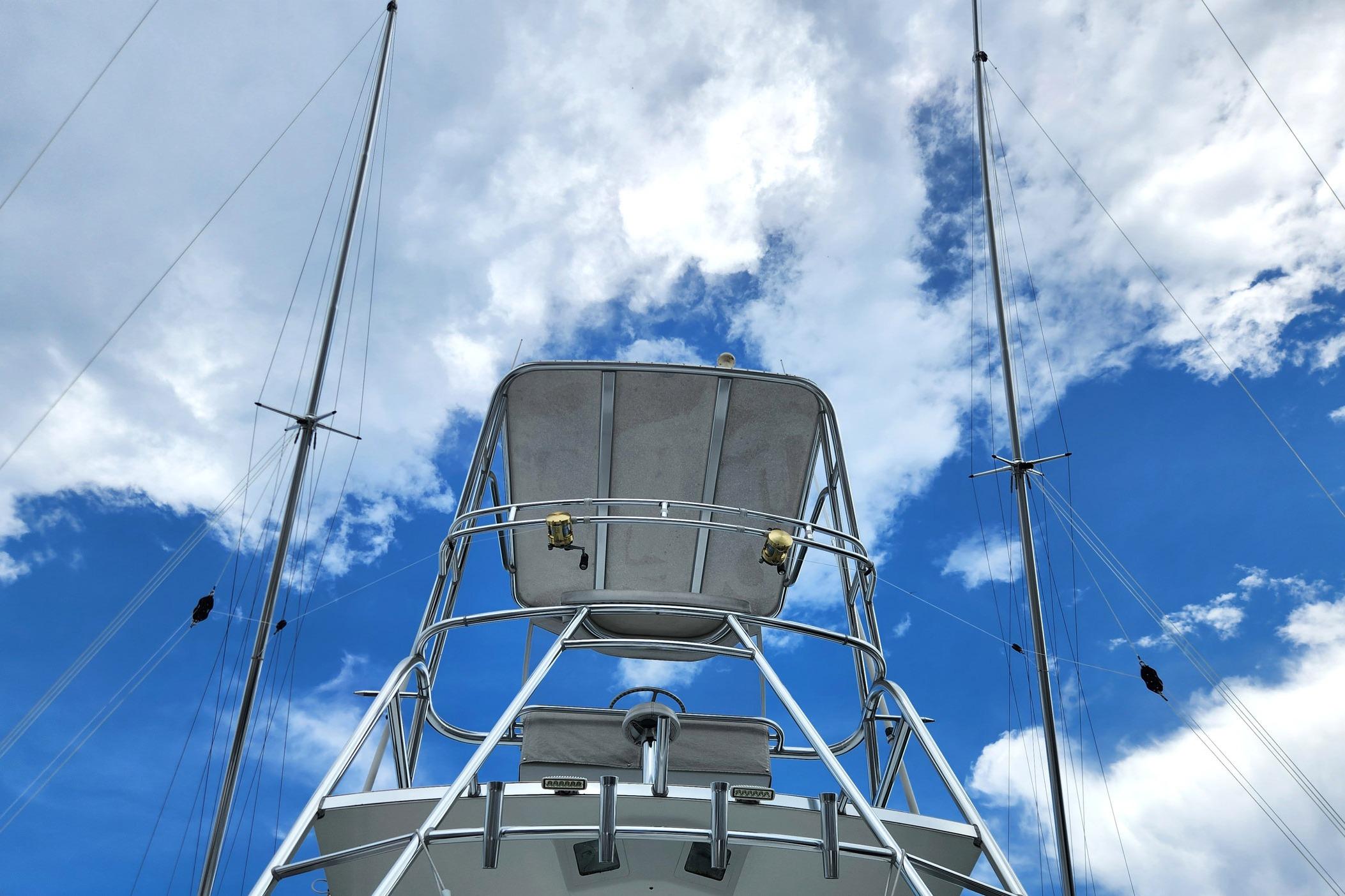 1987 Young Brothers Custom Sport Fish boat against a vibrant blue sky with clouds.