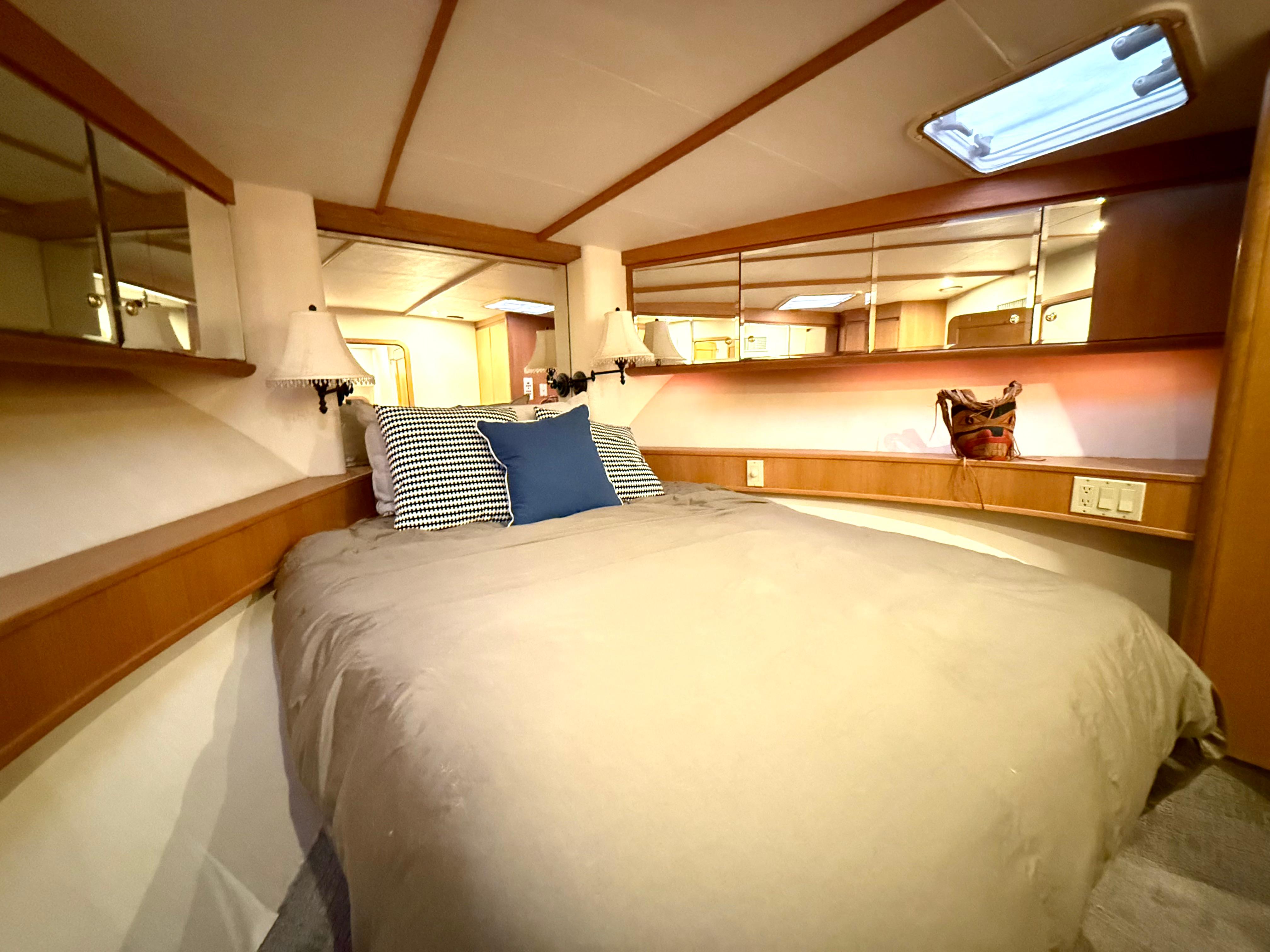 Cozy bedroom in 1997 West Bay Sonship 58 Pilothouse yacht with elegant wood accents.
