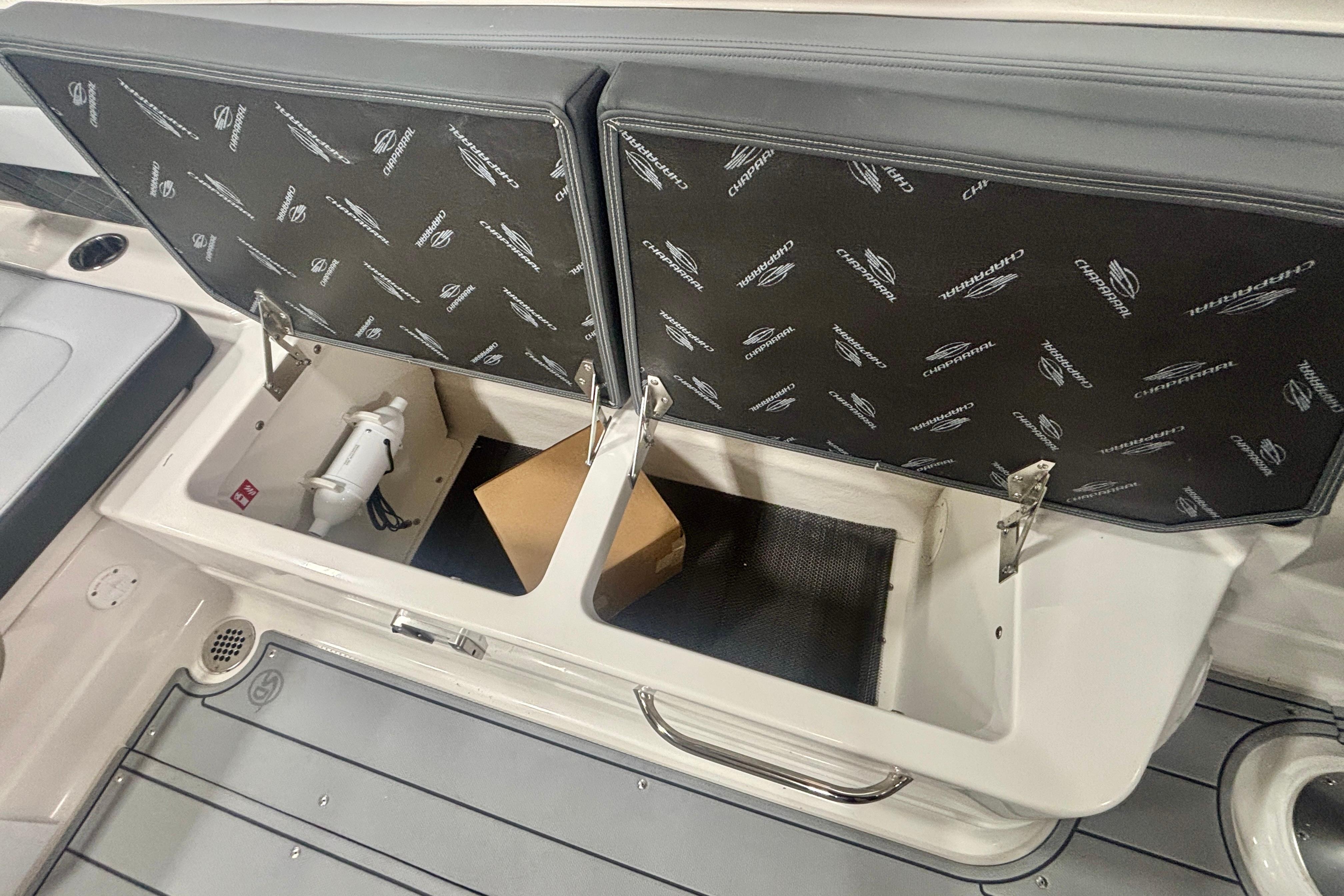 2026 Chaparral SSX 30 boat storage compartment with open lid and visible interior items.