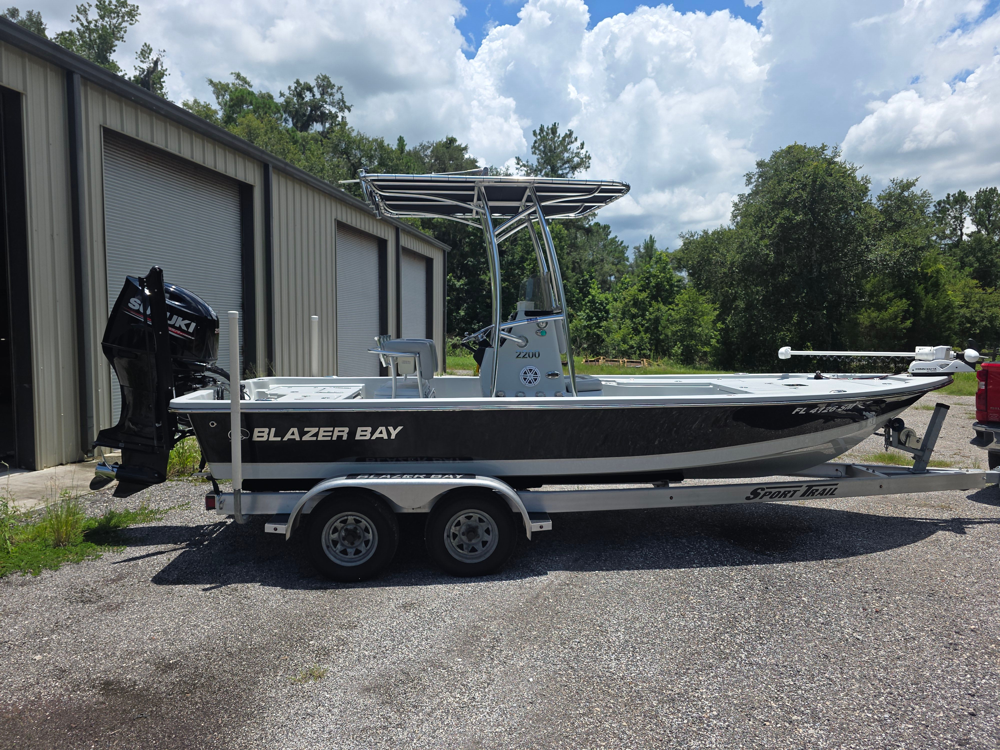 A 2019 Blazer Bay 2200 on a trailer, parked next to a building.