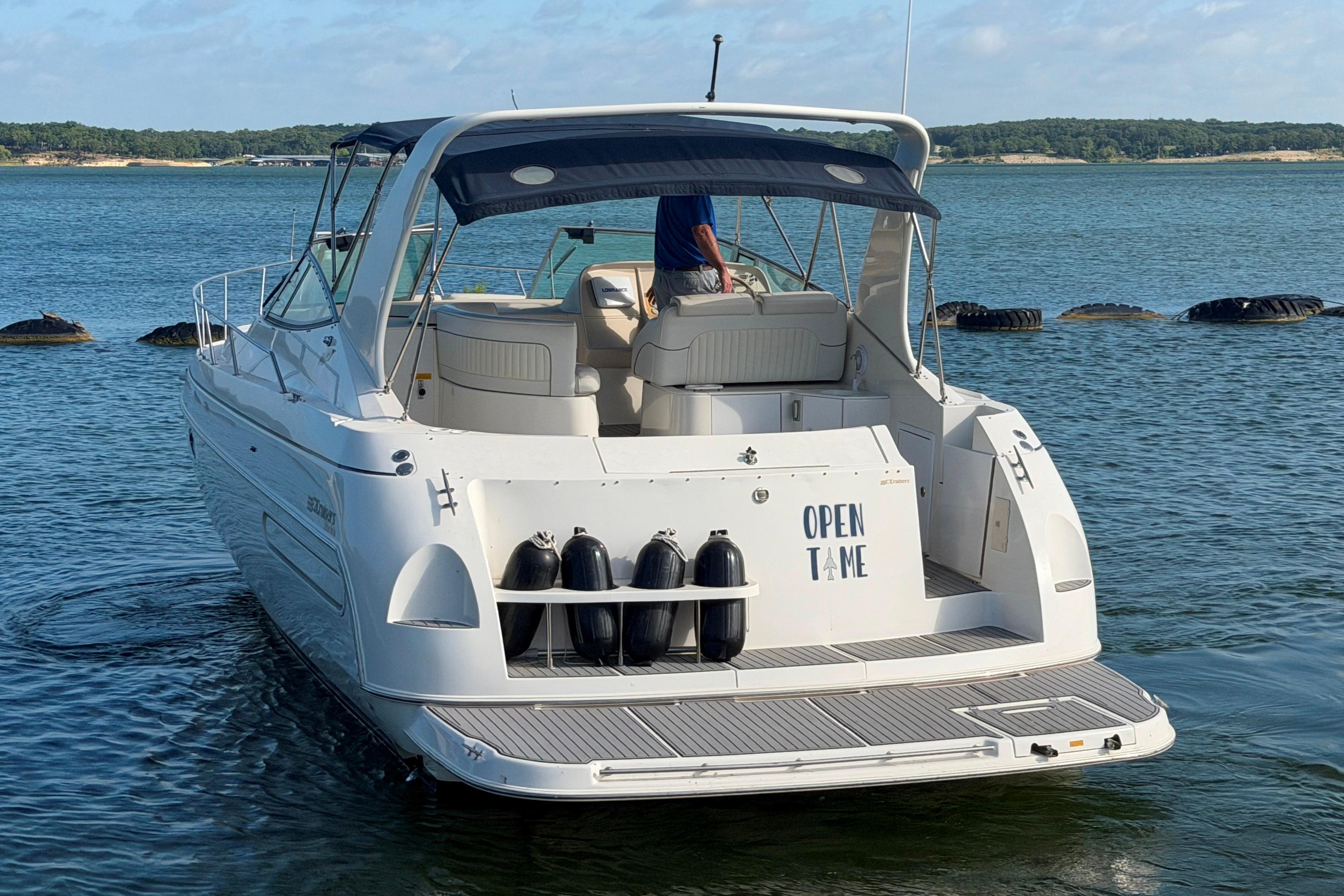 1997 Cruisers 3575 yacht on water, rear view with open deck and canopy.