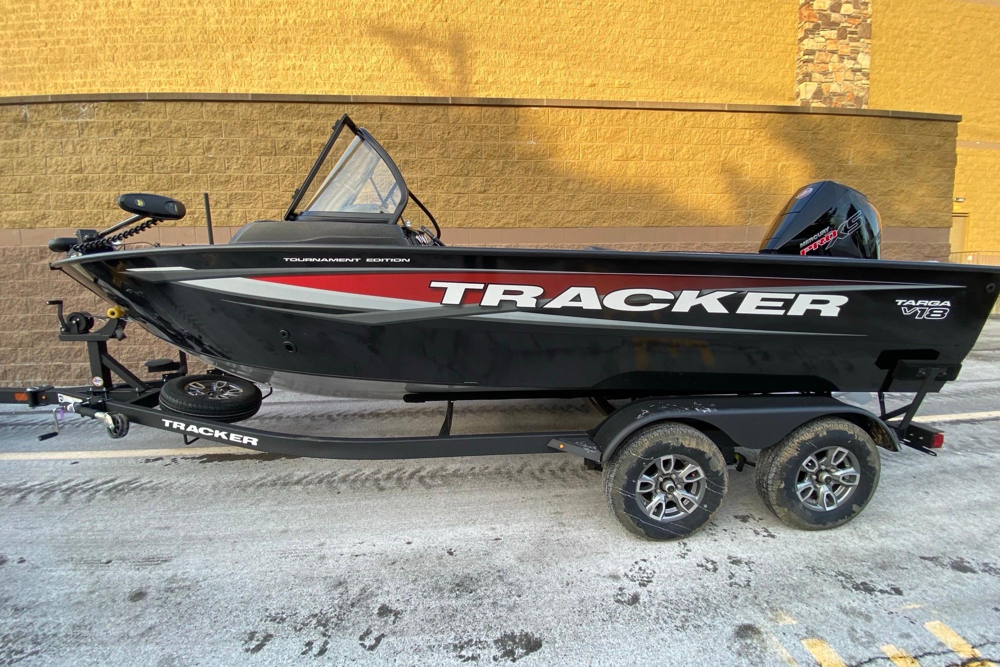 2026 Tracker Targa V-18 Combo boat on trailer, black with red accents, parked outdoors.