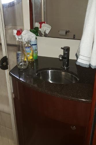 Bathroom sink area in a 2010 Meridian 441 Sedan yacht with cleaning supplies.