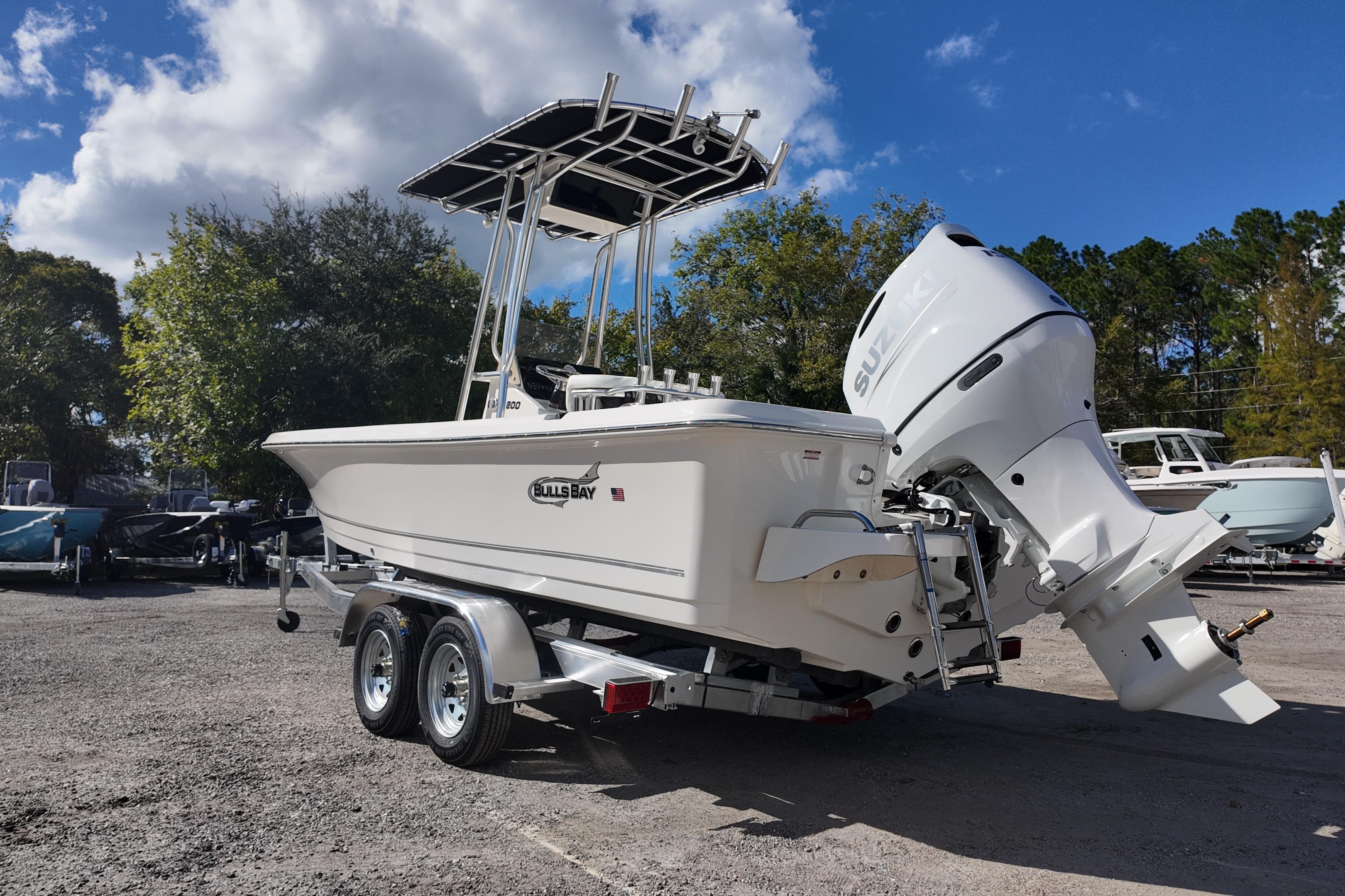 2026 Bulls Bay 2200 boat on trailer with Suzuki outboard motor, parked outdoors.