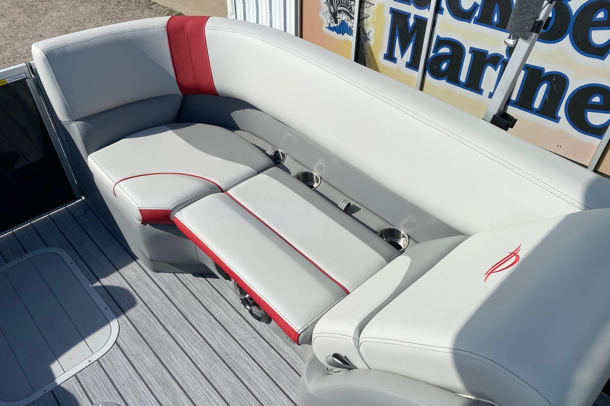 Luxurious seating on 2026 SunCatcher Select 322RC pontoon boat with red accents and cup holders.