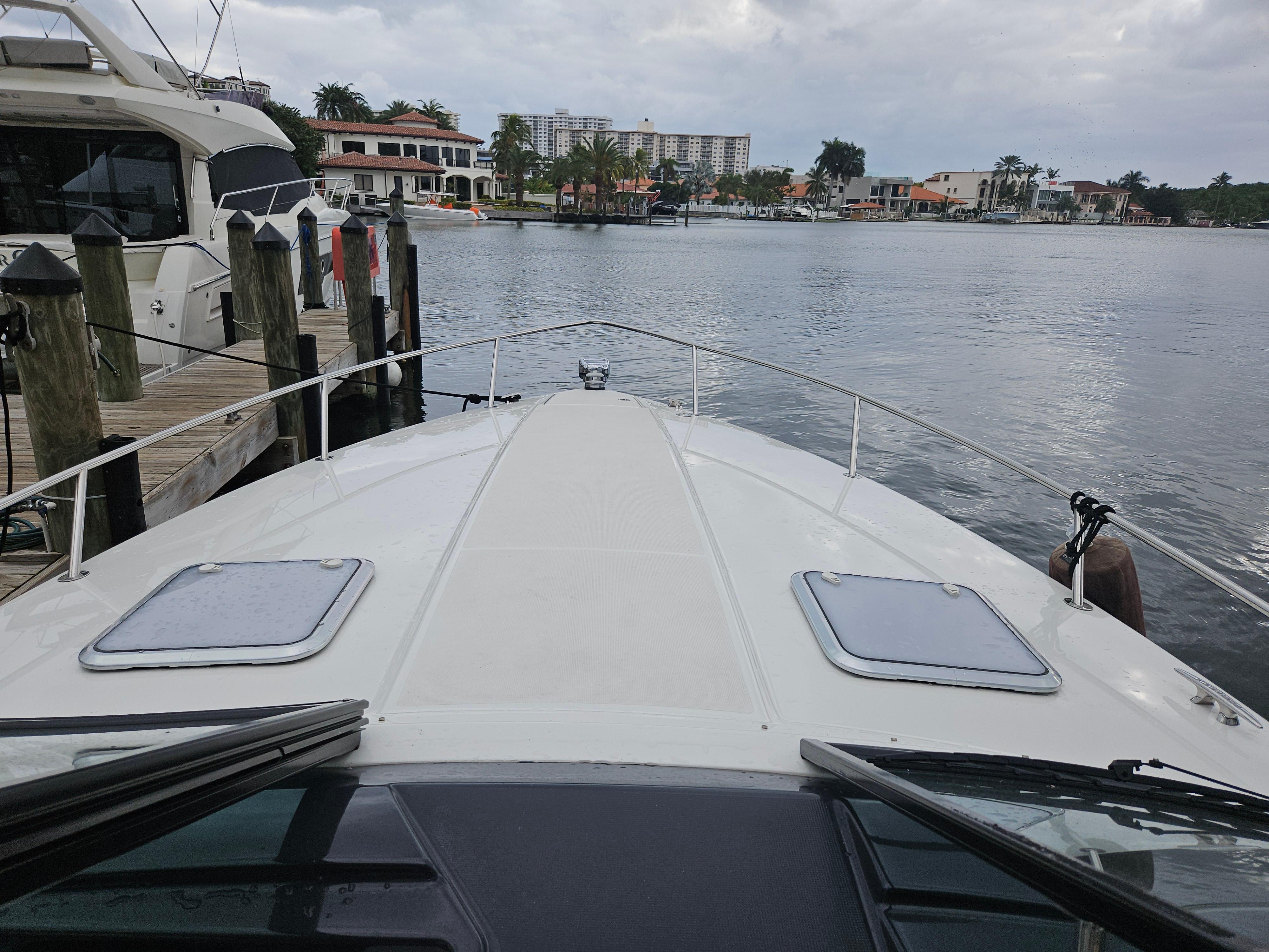 2018 Formula 350 Sun Sport boat docked by waterfront homes.