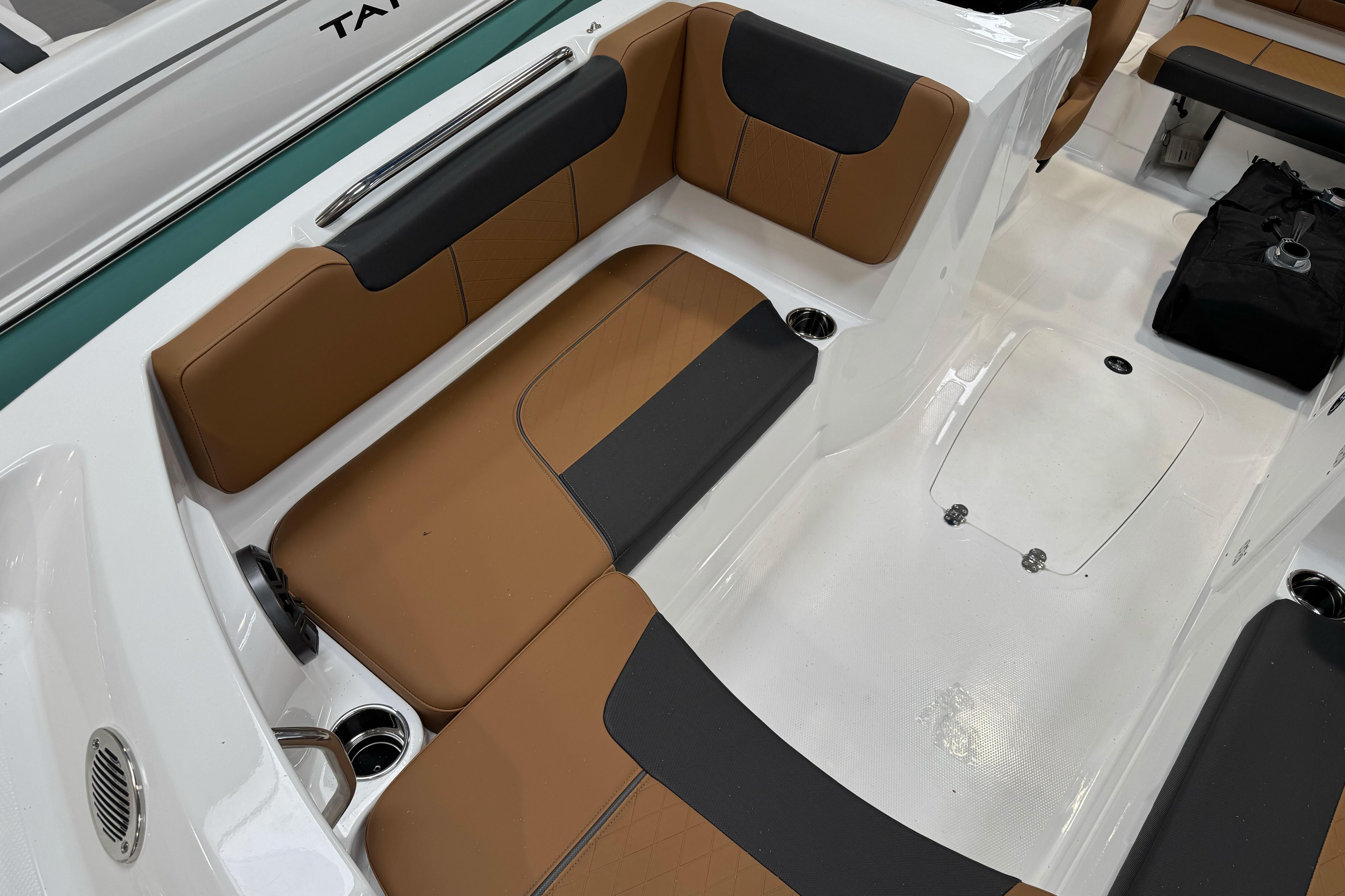 2026 Tahoe 2150 boat interior with brown and black seating, cup holders, and storage compartments.
