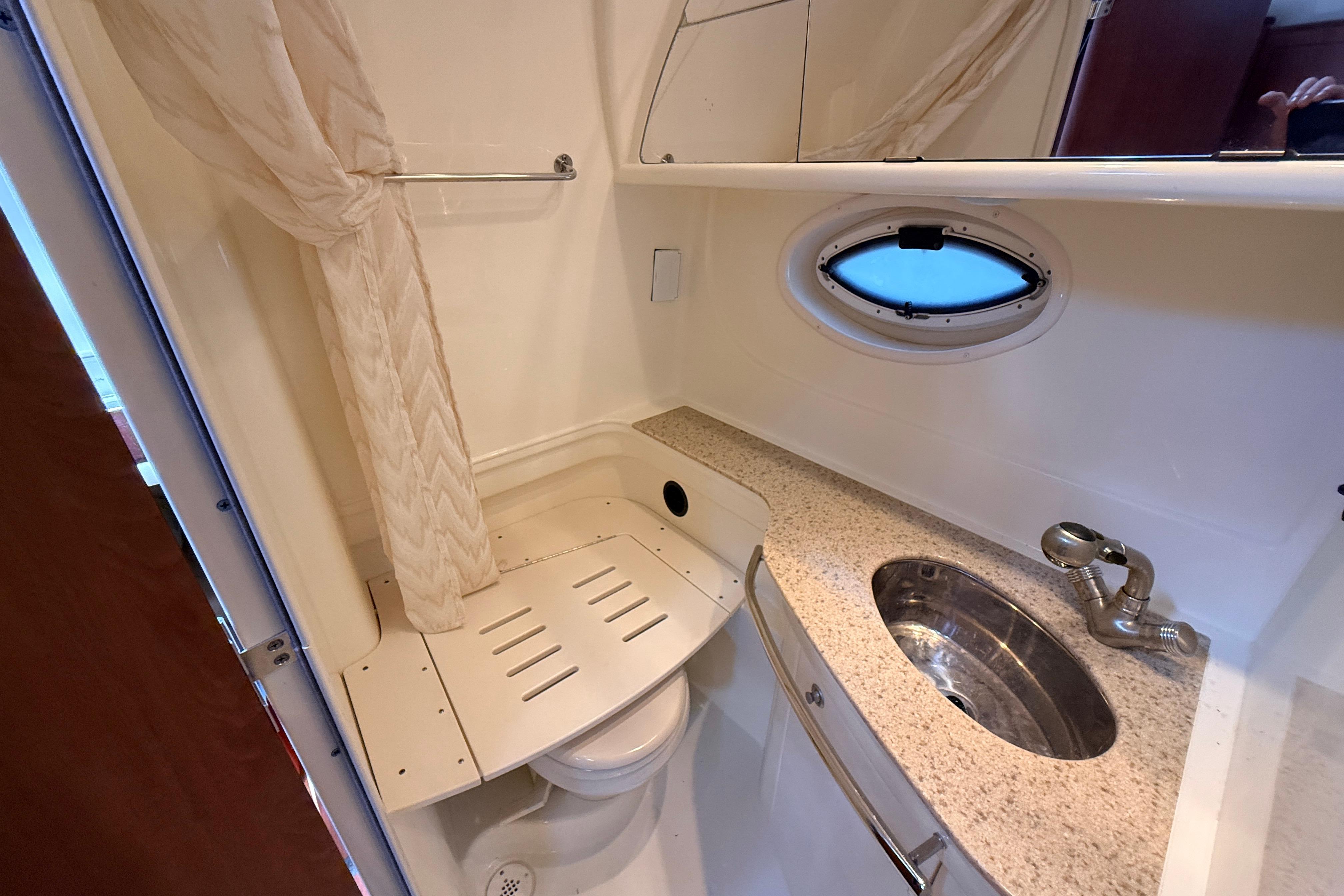 2011 Monterey 320 Sport Yacht bathroom with sink, shower, and porthole window.