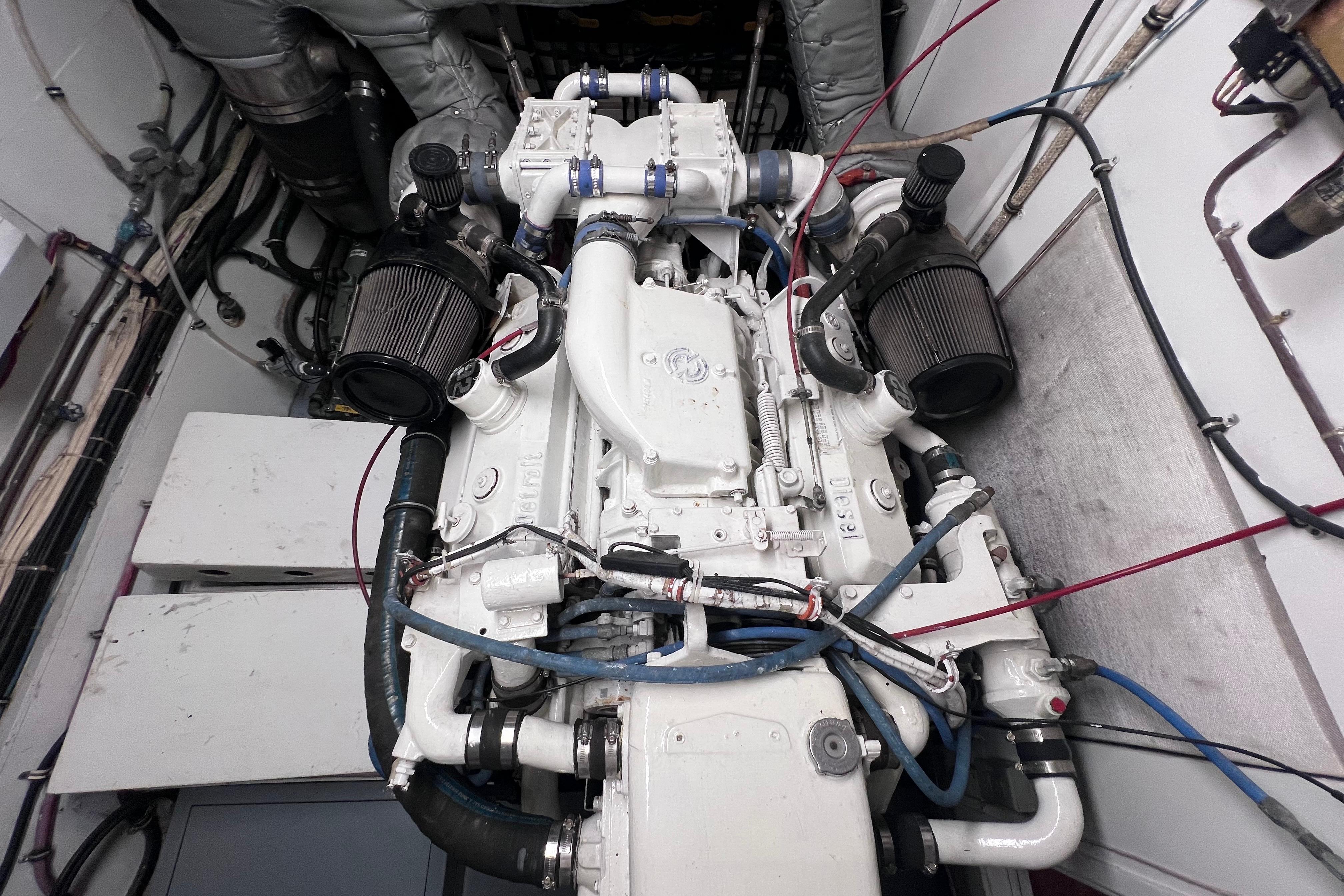 Engine room of 1987 Hatteras 70 Cockpit Motor Yacht, showcasing detailed machinery and components.