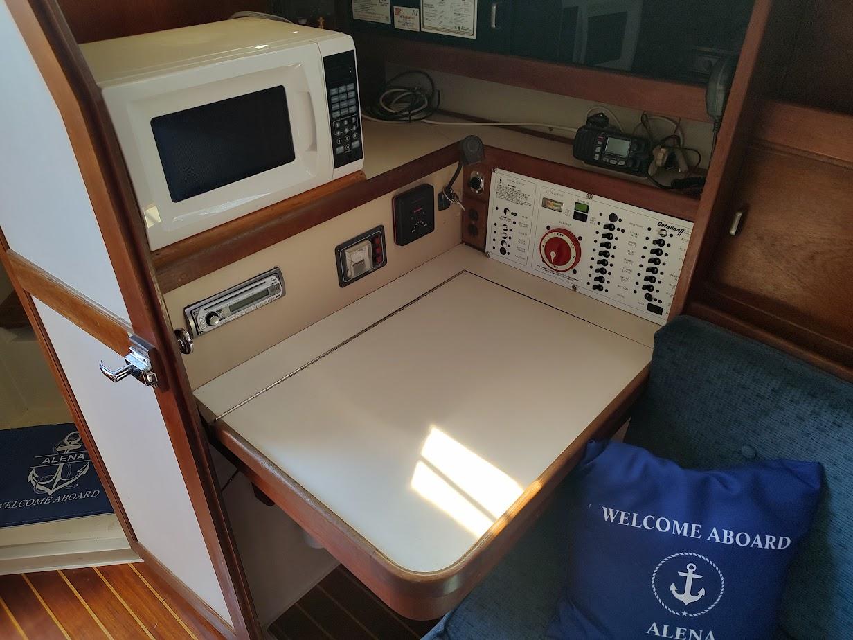 1987 Catalina C-34 yacht interior with microwave, control panel, and welcome pillow.