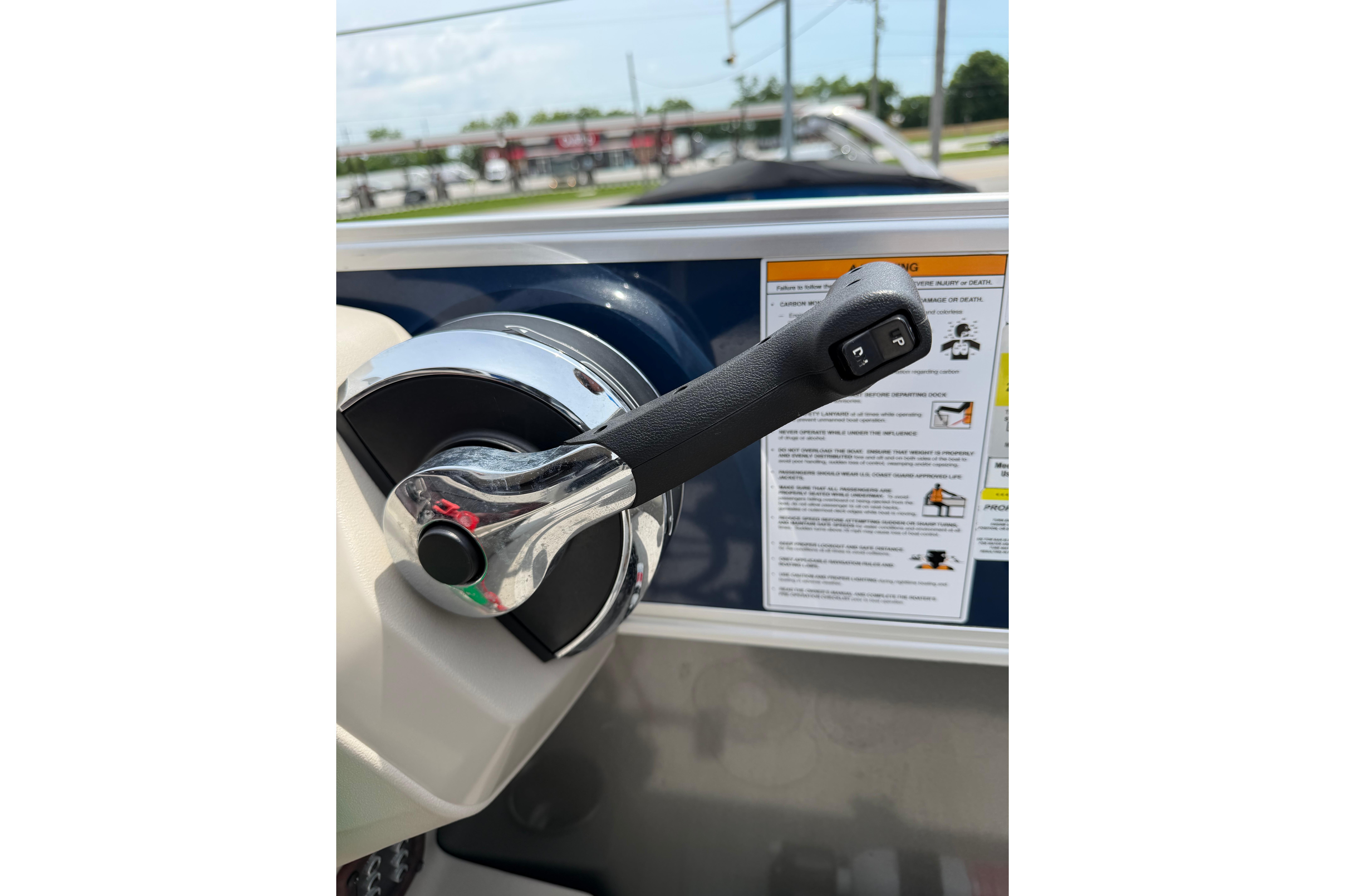 Throttle control of 2021 South Bay 224RS LE boat with warning labels in background.