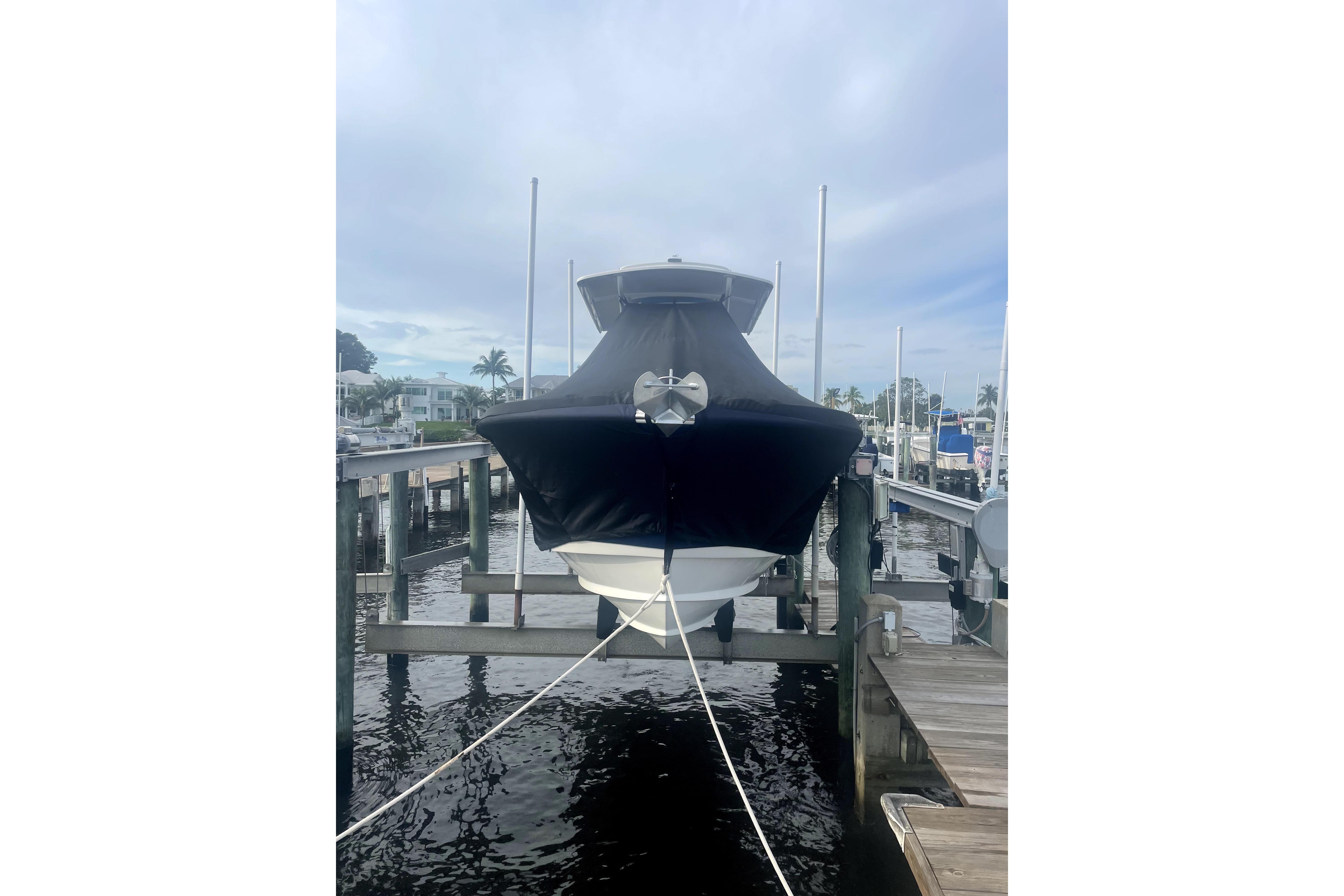 2015 Edgewater 245CC boat docked with cover, in a marina setting.