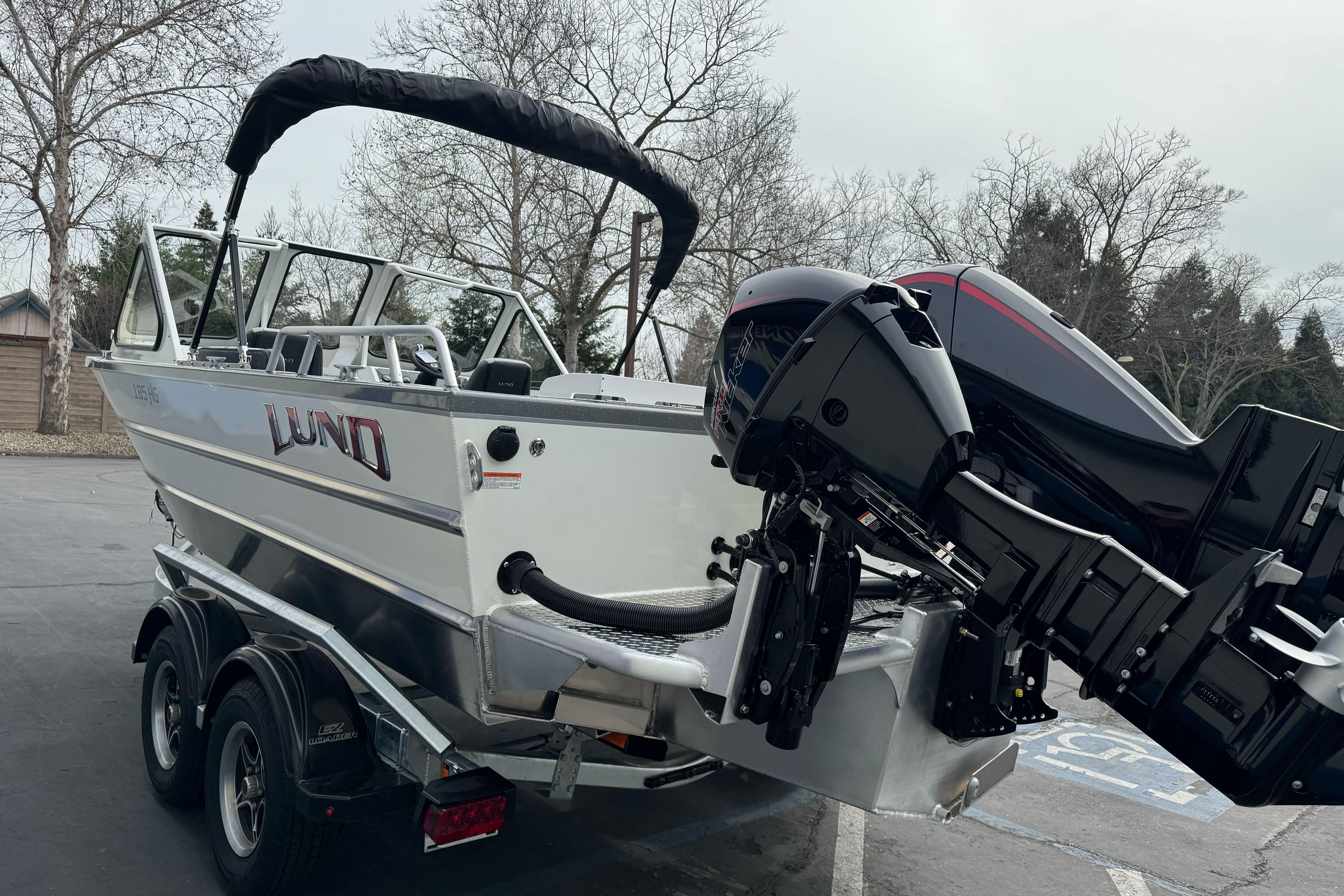 2026 Lund 185 Heavy Gauge boat with dual outboard motors on a trailer.