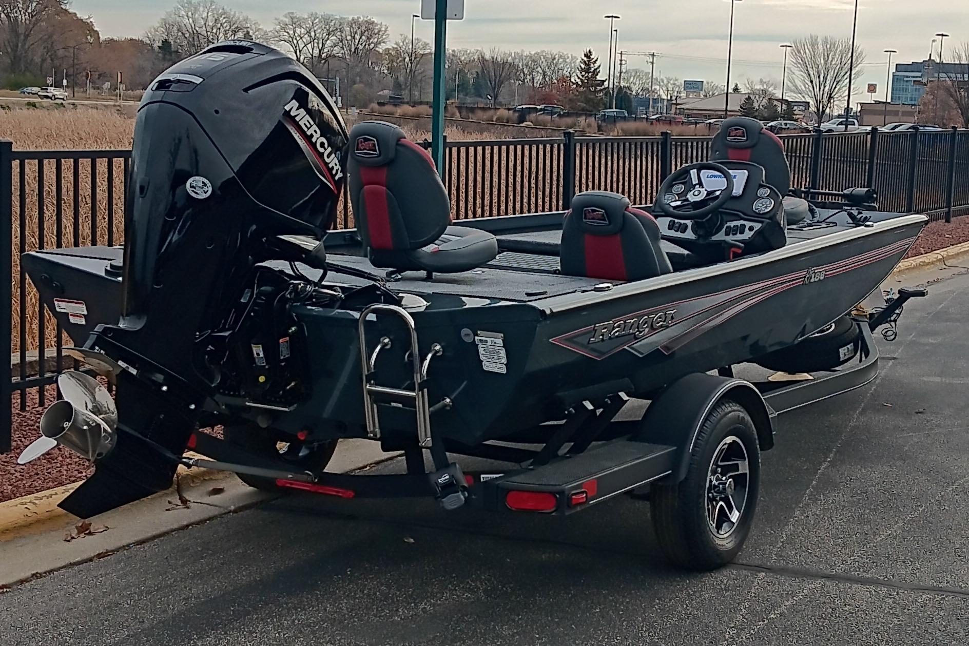 2026 Ranger RT188 boat with Mercury engine, parked on a trailer near a fence.