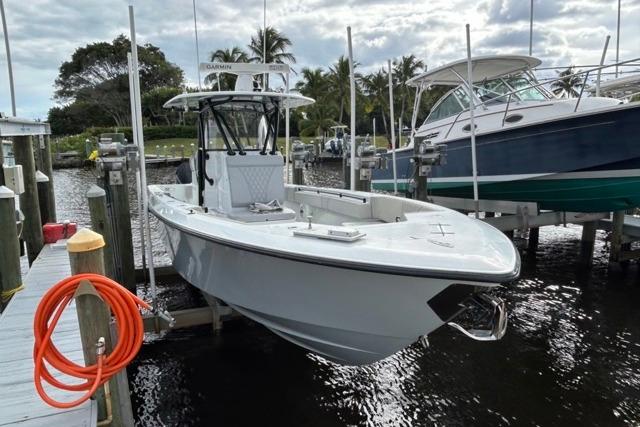 2023 Contender 32 ST boat docked at marina with palm trees in background.